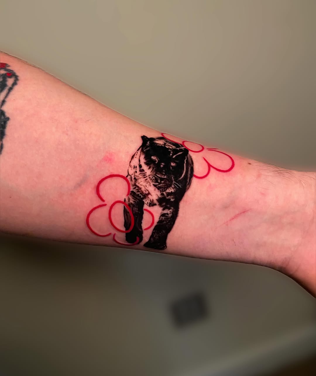 Panther black and grey tattoo on the forearm by Ezra Gonda