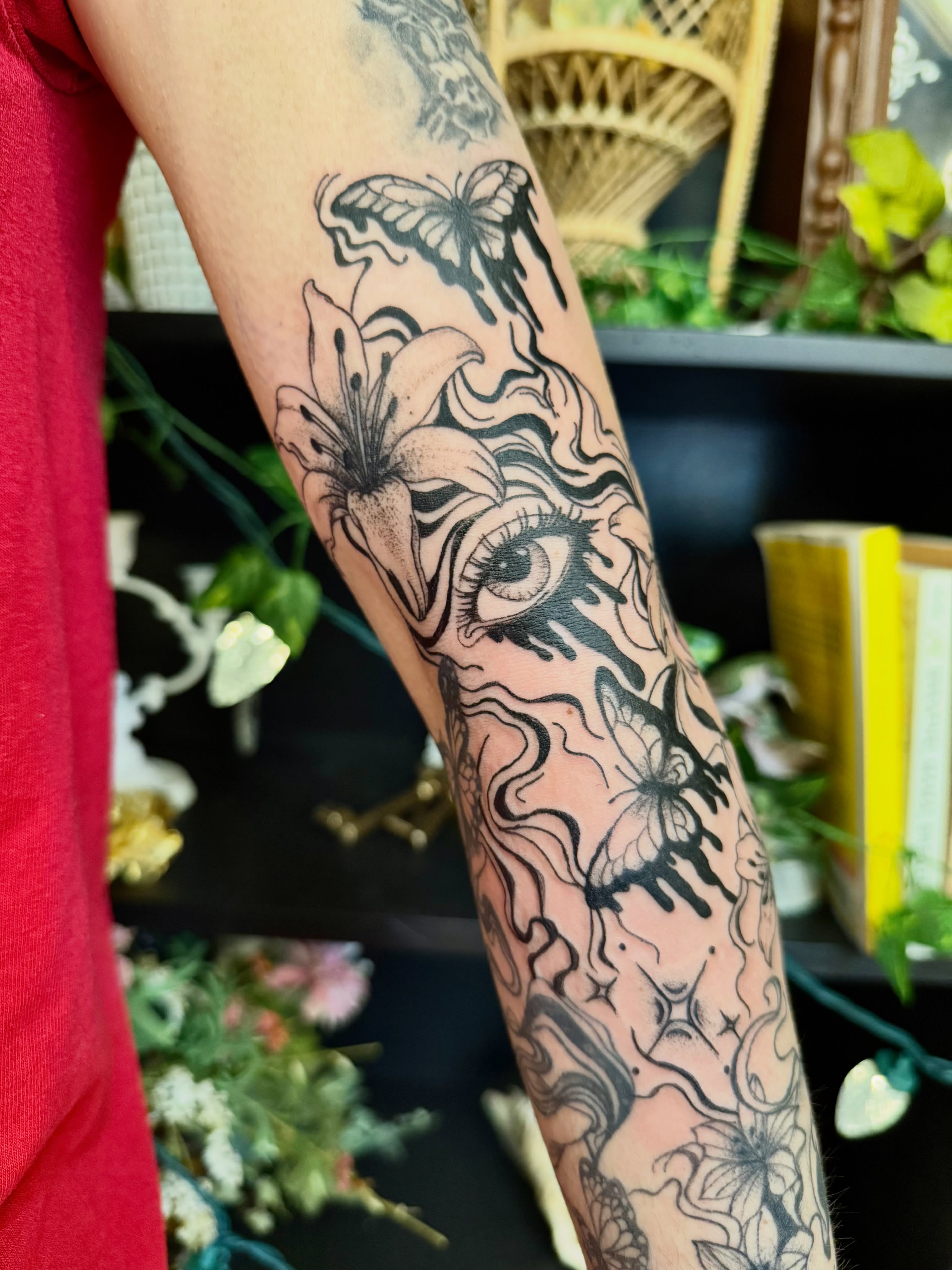 Lily and butterfly black and grey tattoo on the forearm by Haley Bates