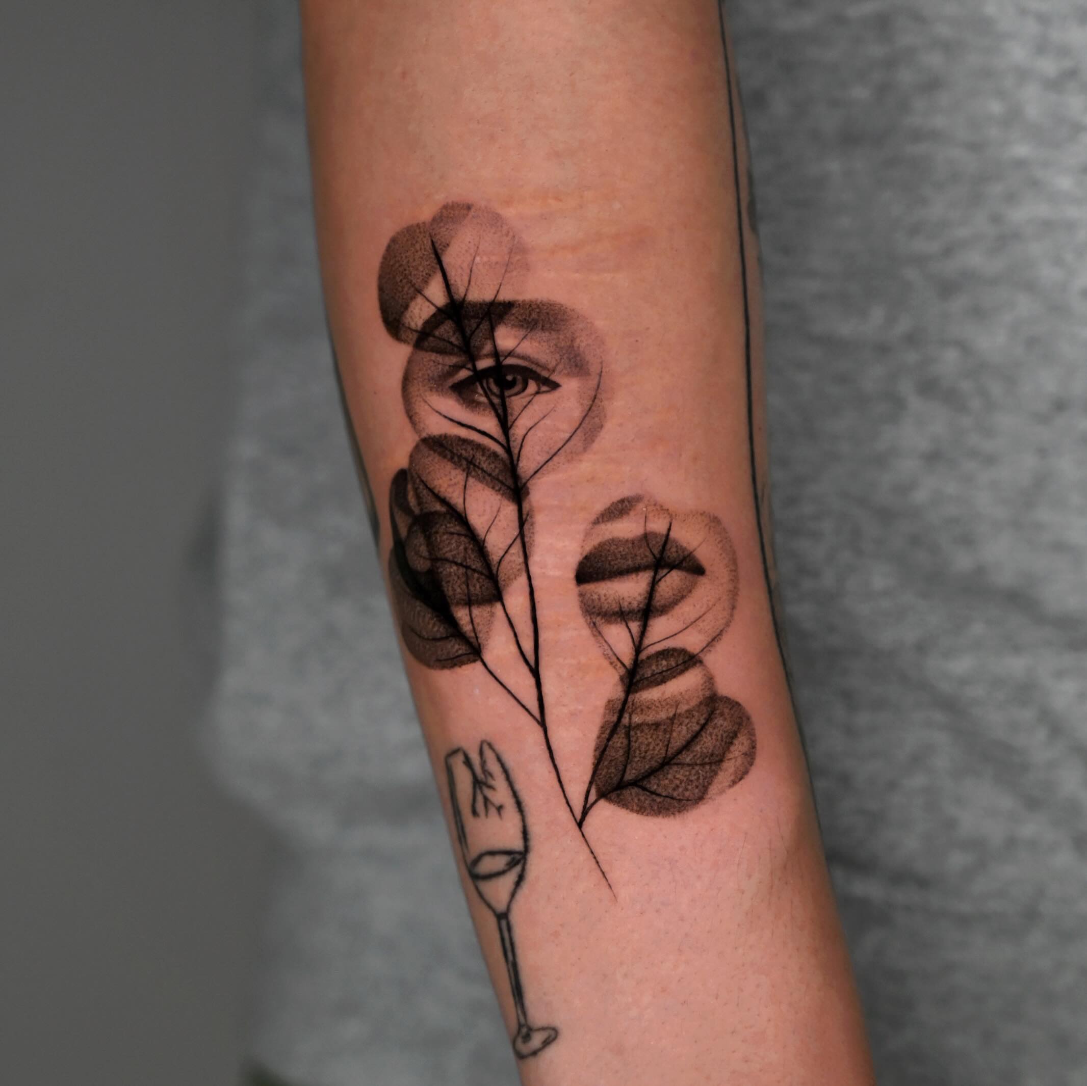 Abstract face minimalist tattoo on the forearm by dom