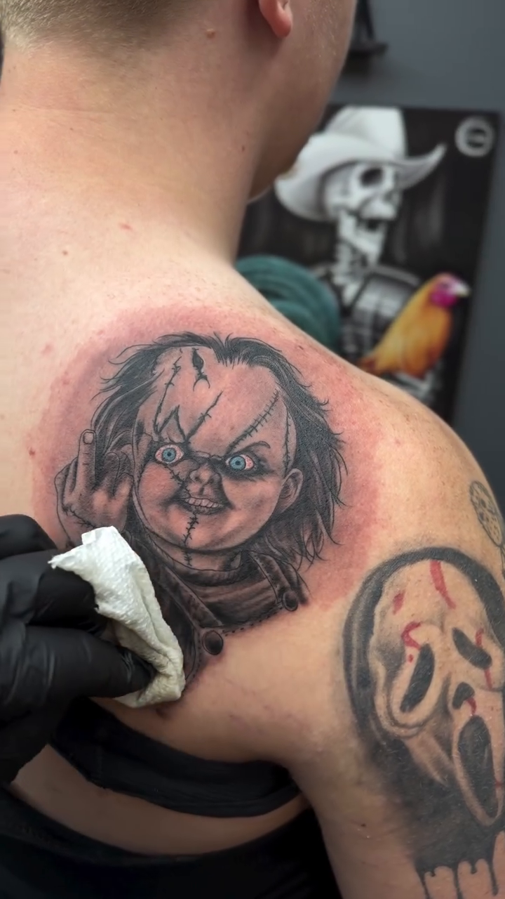 Chucky doll realism tattoo on the shoulder by Oscar Saldaña