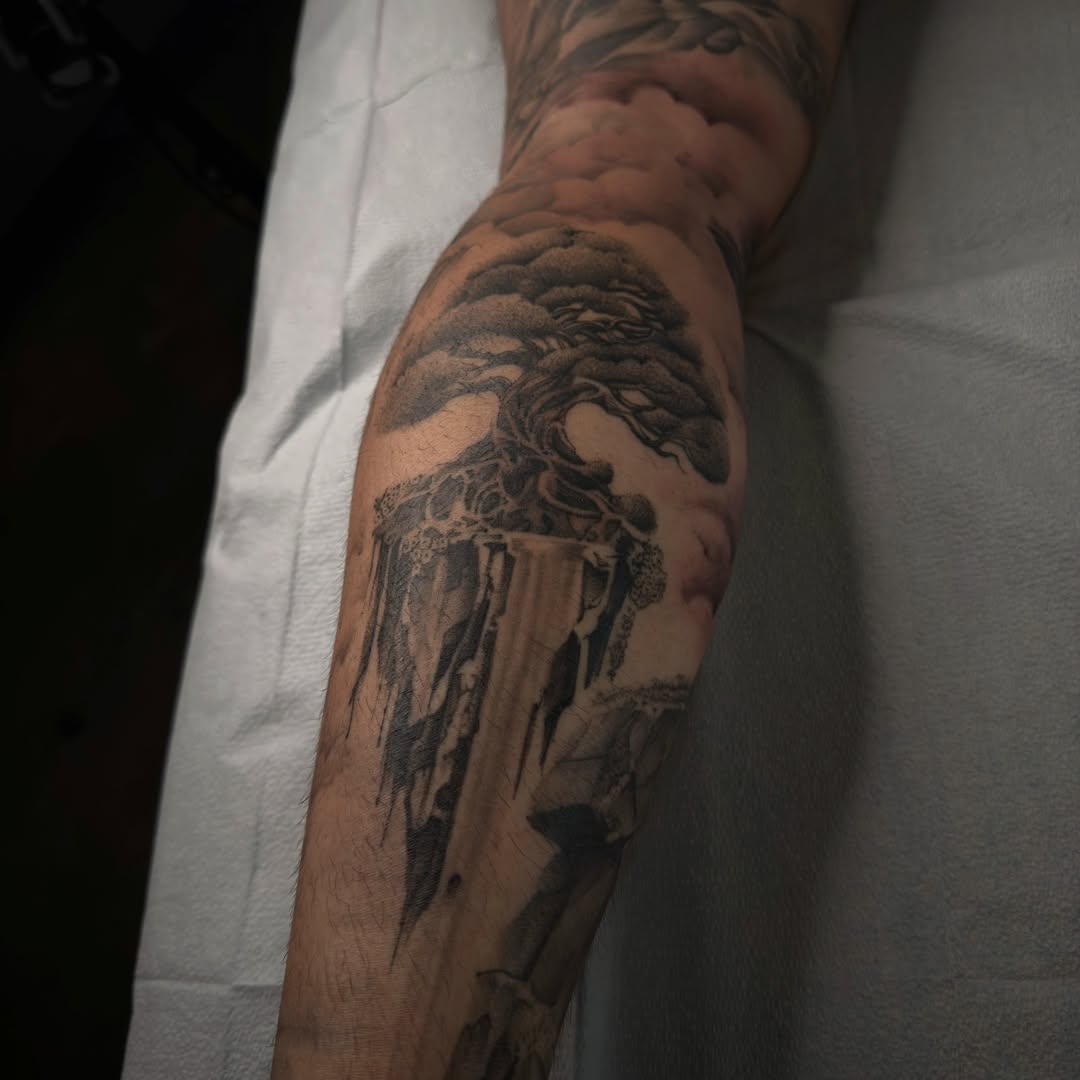 Tree and cityscape realism tattoo on the forearm by Joe Cruz