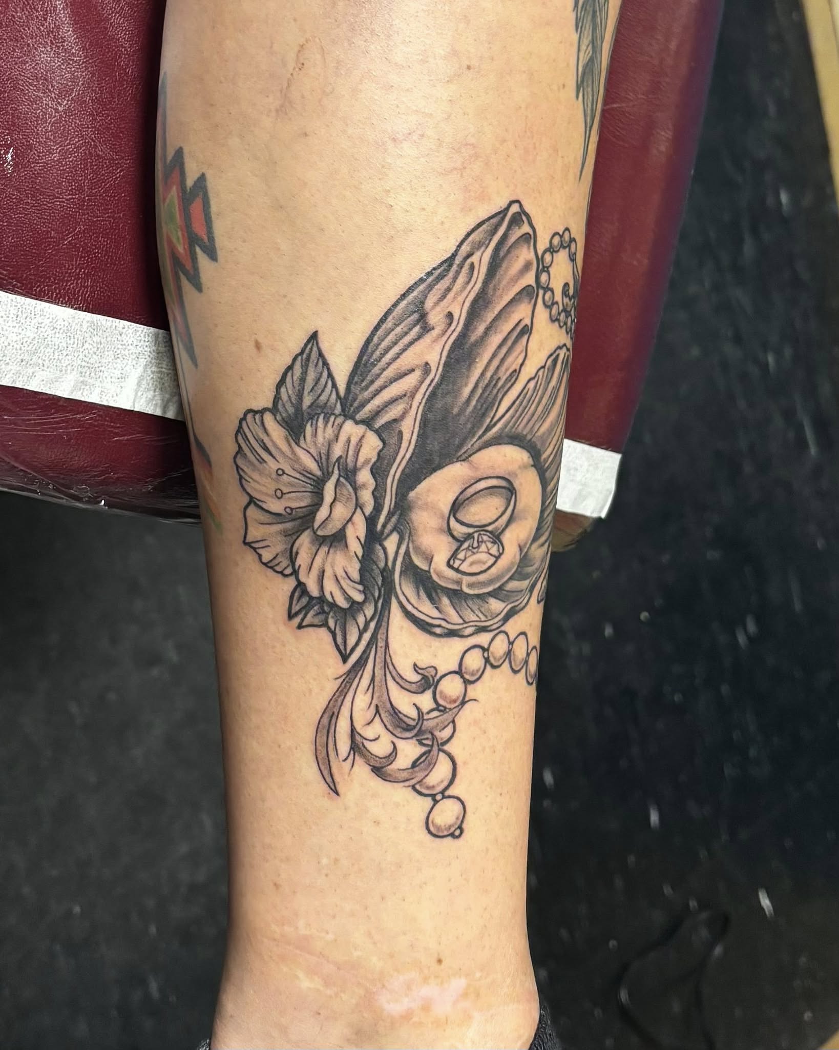 Skull and flowers black and grey tattoo on the forearm by Jeff Zuptich