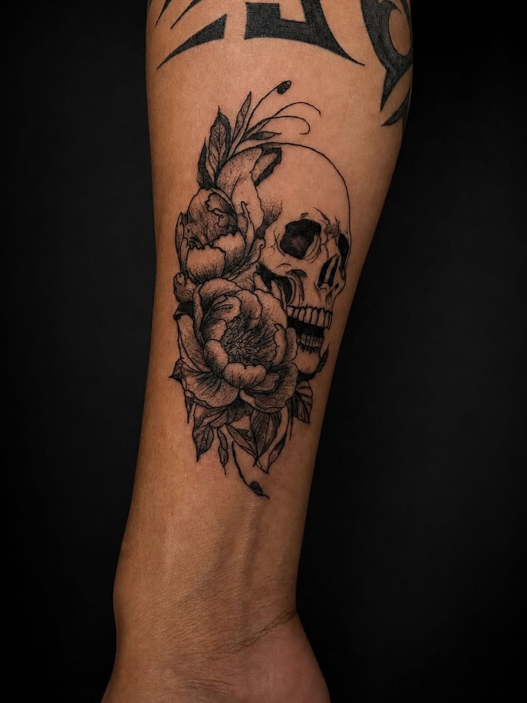 Skull and flowers realism tattoo on the forearm by 𝚃𝙰𝚃𝚃𝙾𝙾 𝙰𝚁𝚃𝙸𝚂𝚃, Charlotte, North Carolina