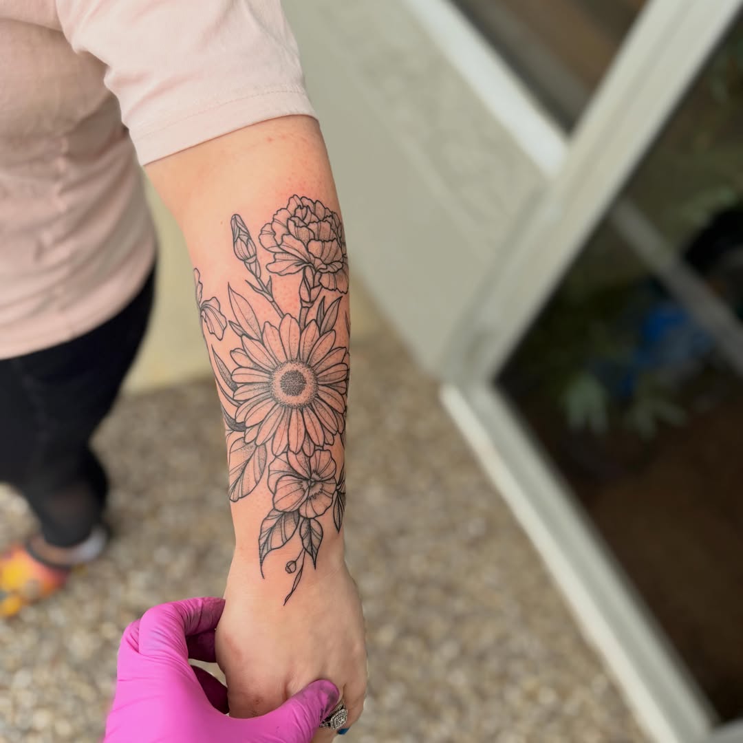Floral arrangement black and grey tattoo on the forearm by Erica Rose π€