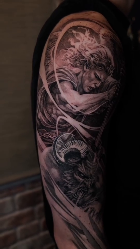 Angel and demon sleeve realism tattoo on the upper arm by Ana Fajardo