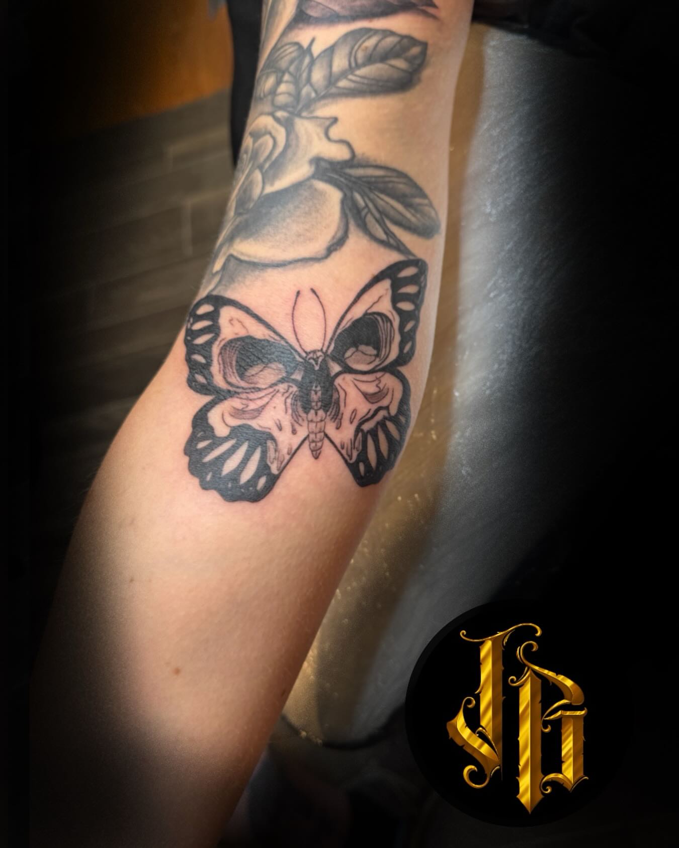 Butterfly skull black and grey tattoo on the forearm by James Brooks
