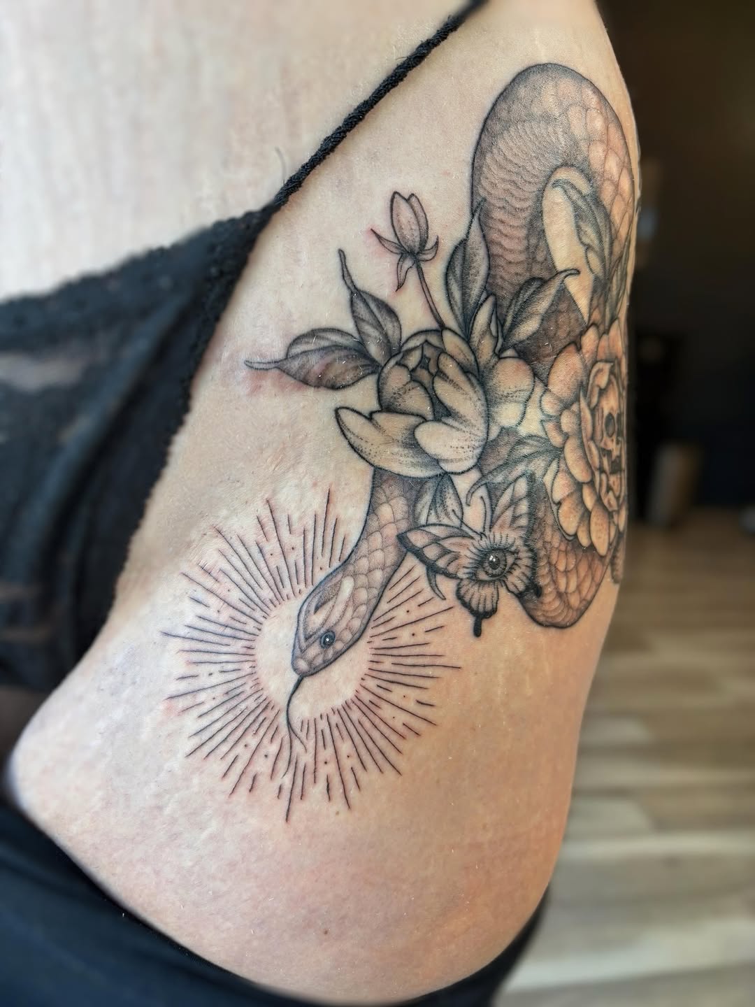 Snake and flowers fine line tattoo on the shoulder by Bianca Cattapan