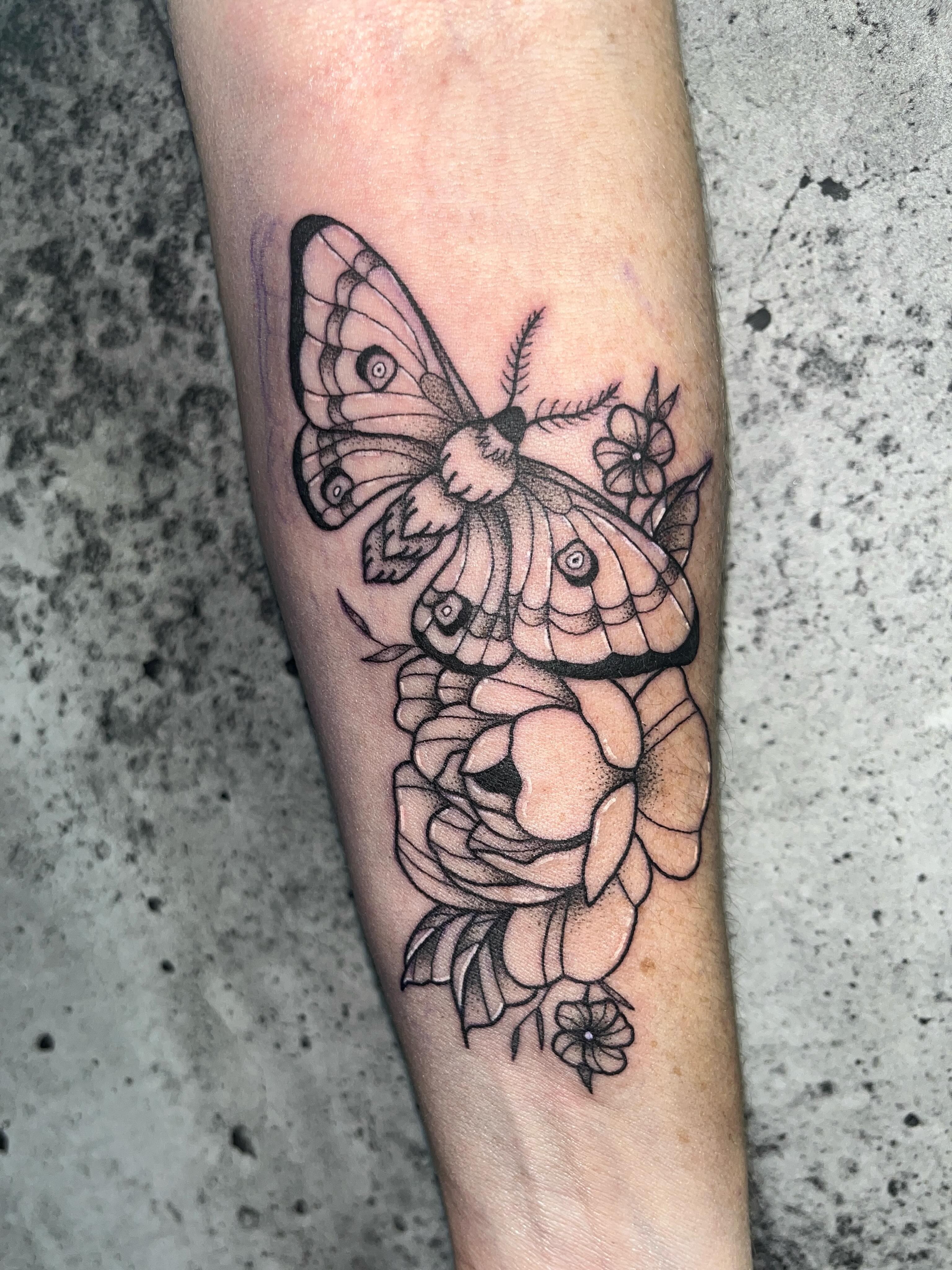 Moths and roses dotwork tattoo on the forearm by Scout Meyer