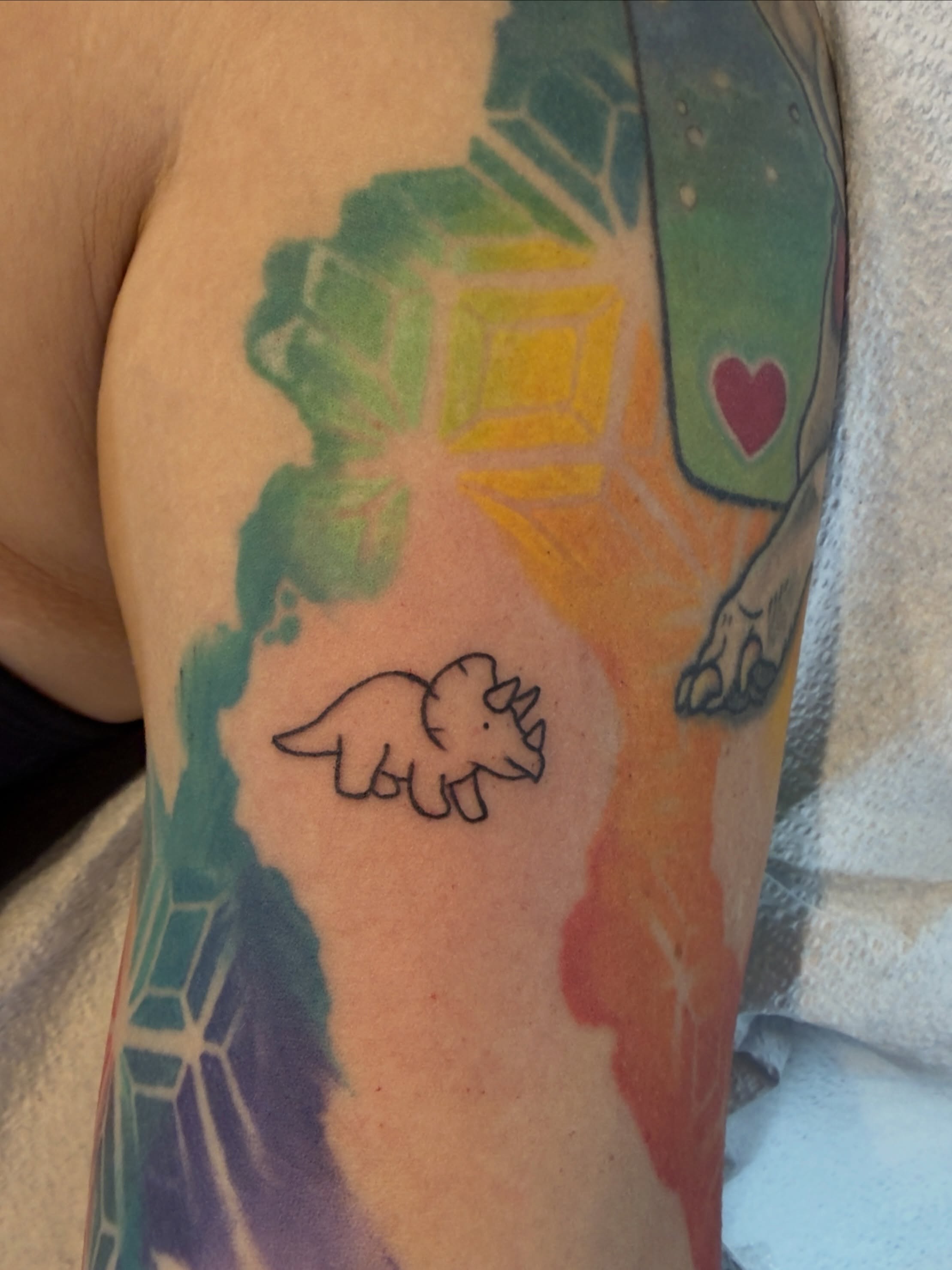 Dinosaur minimalist tattoo on the forearm by Charlotte (Luna), Seattle, Washington