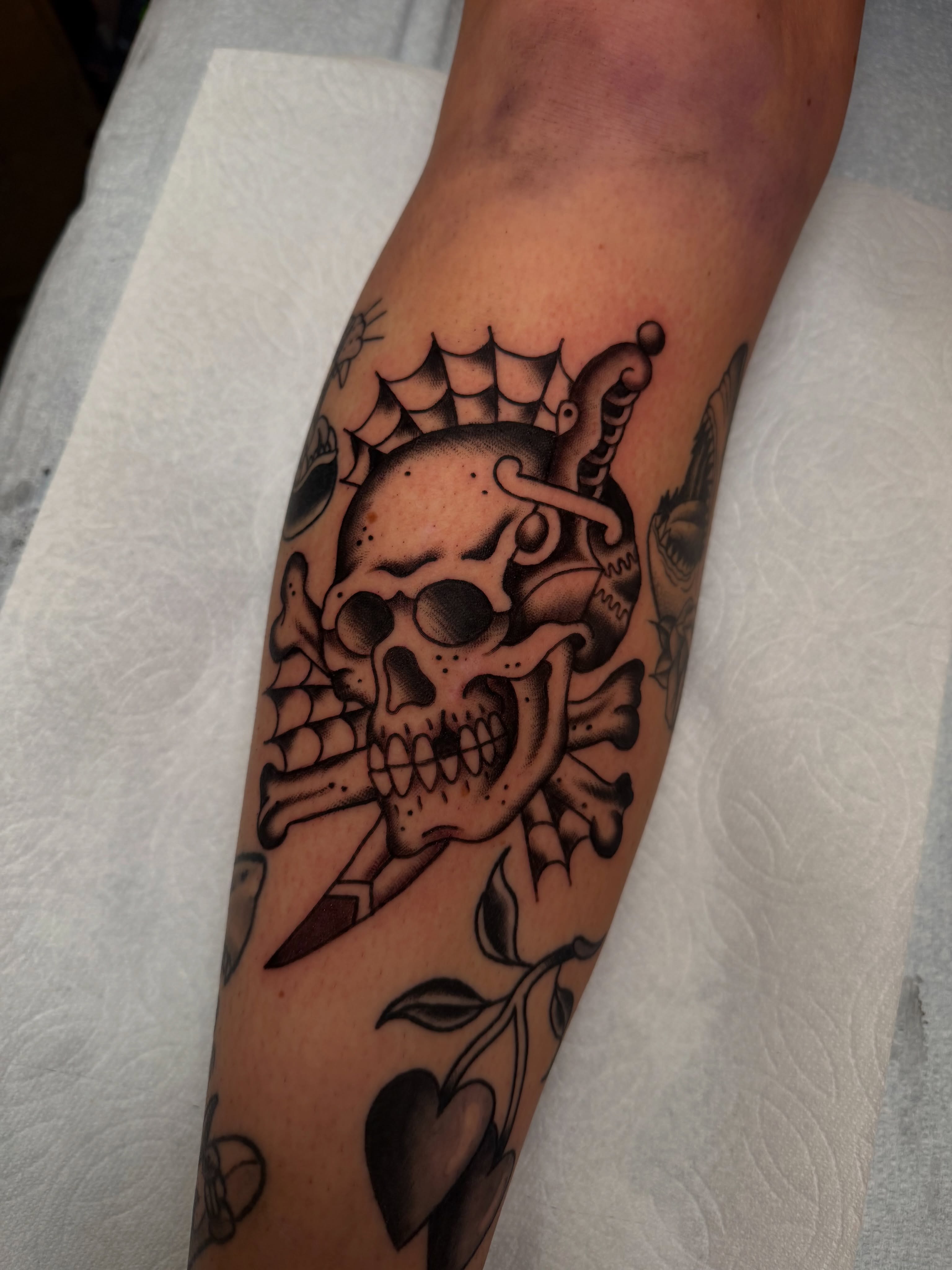 Skull and crossbones American traditional tattoo on the forearm by Tyler Brown, San Diego, California