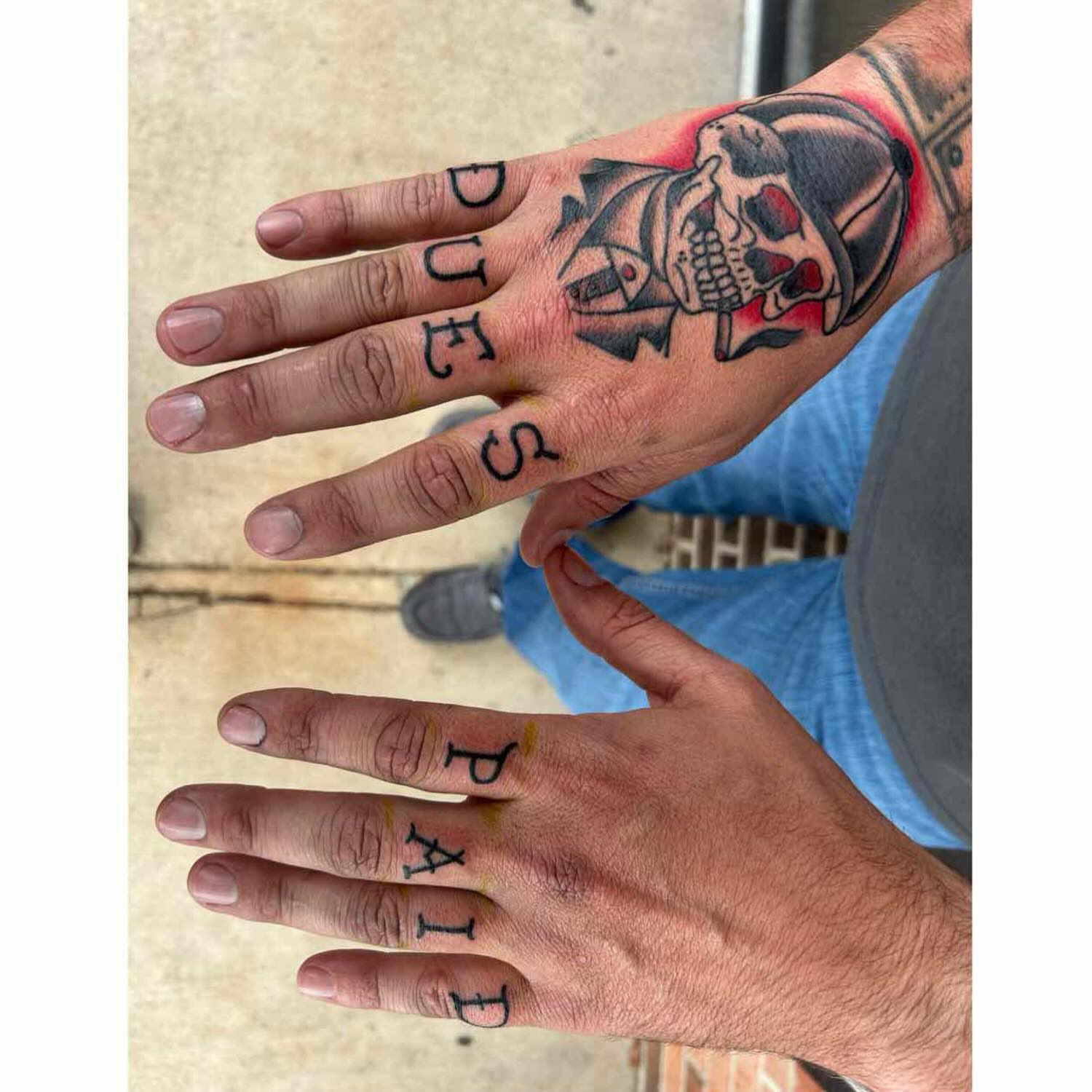 Skull and lettering American traditional tattoo on the hand by Zach Andrews