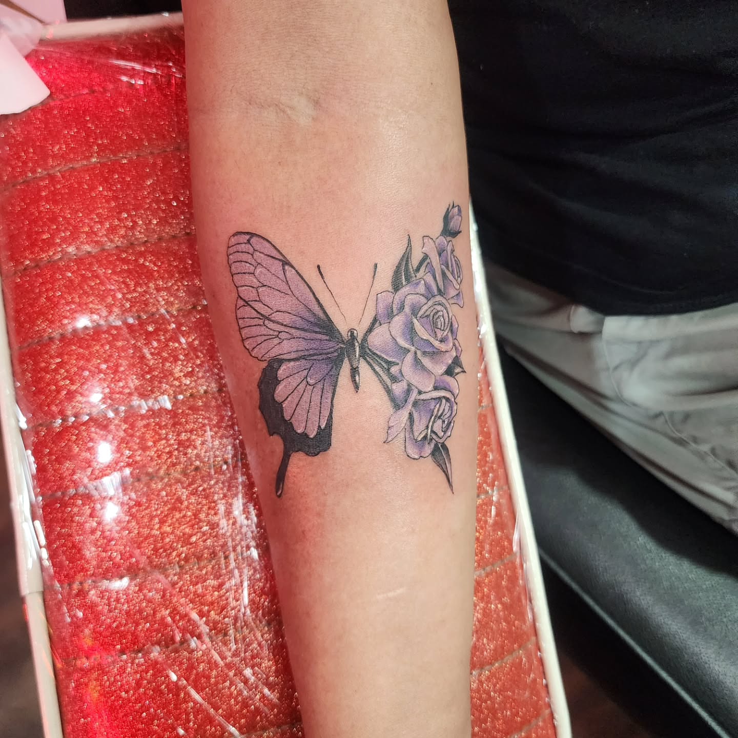 Butterfly and roses realism tattoo on the forearm by Joe Garcia