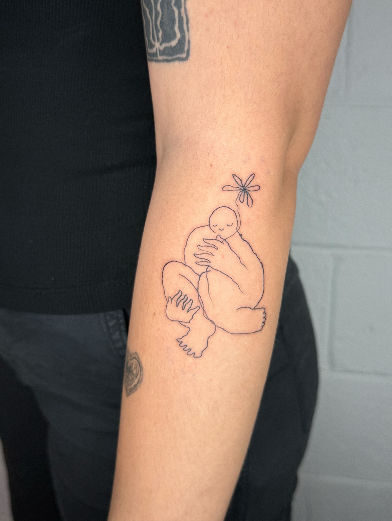 Mother and child minimalist tattoo on the forearm by Eden Kalif