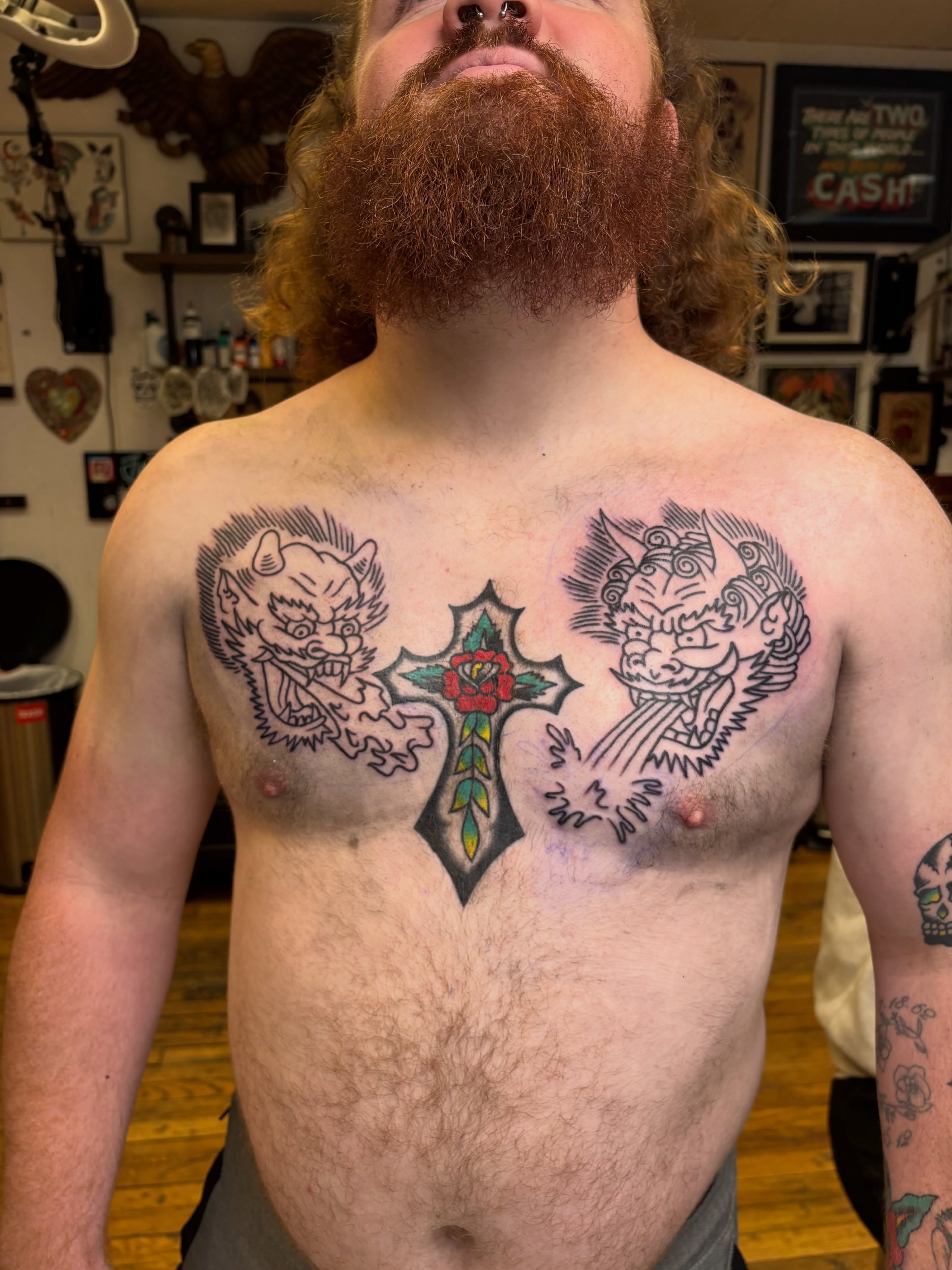 Cross with roses American traditional tattoo on the chest by Cooper Reichwein