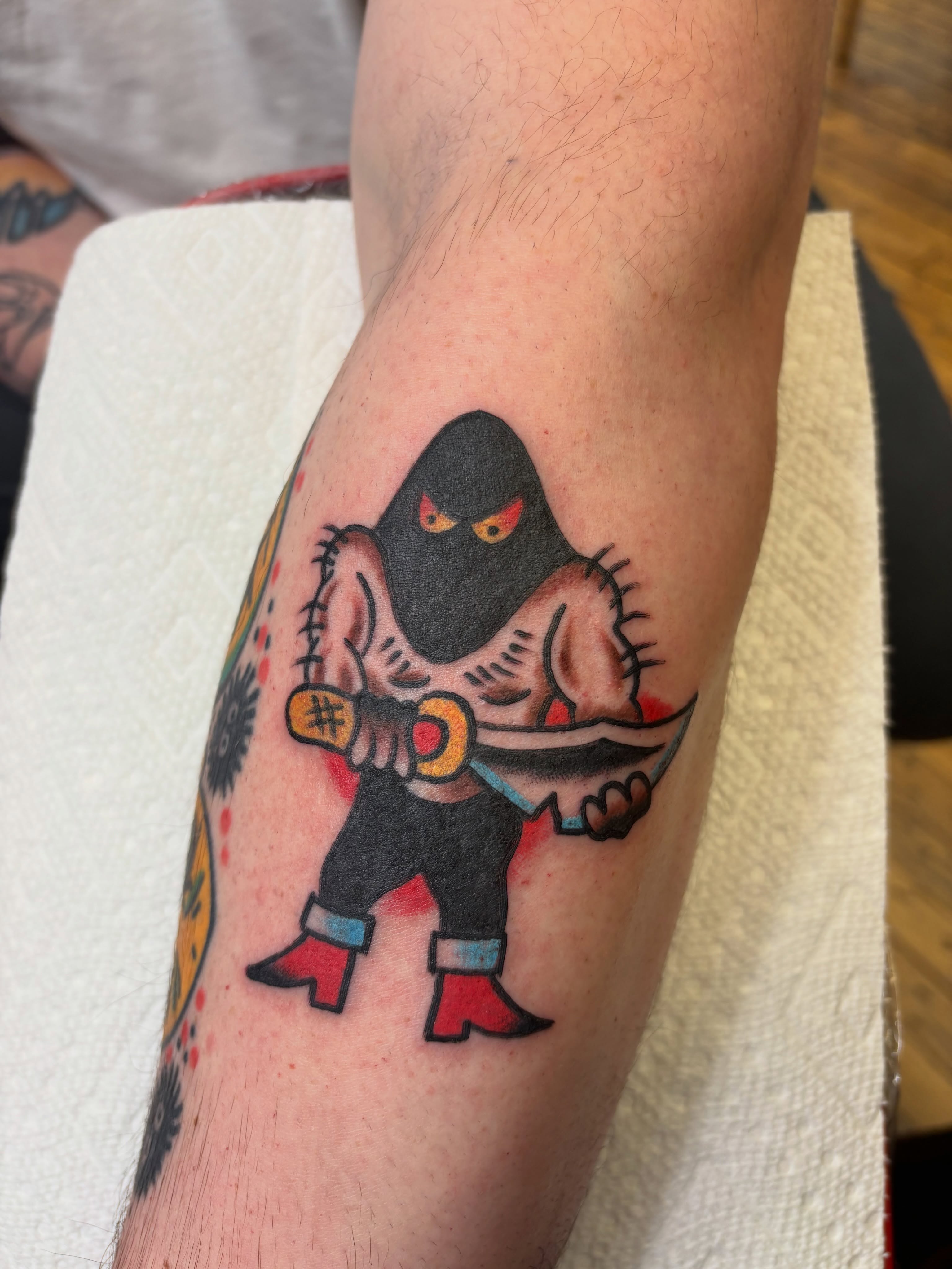 Cat-like figure American traditional tattoo on the forearm by Cooper Reichwein