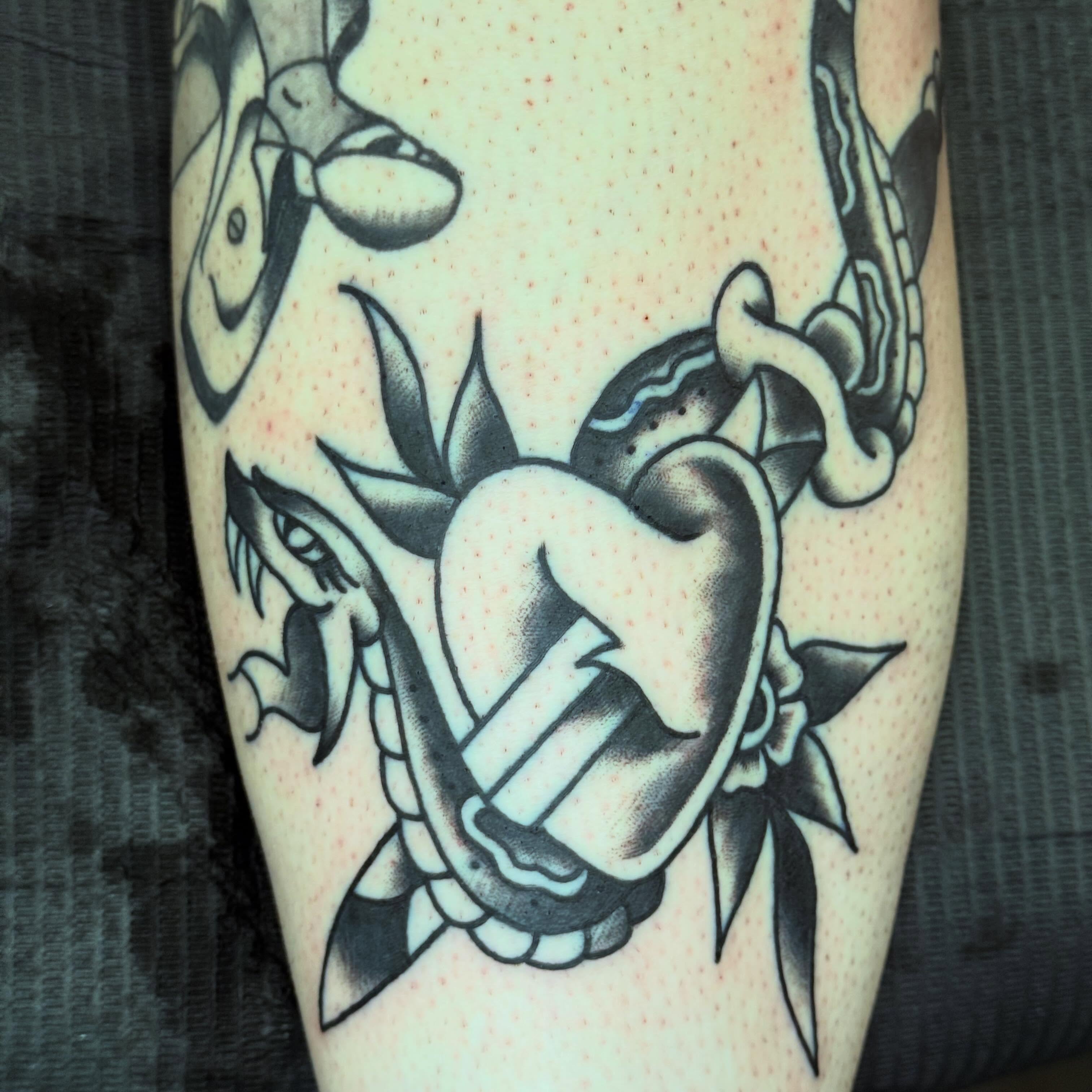 Heart with snake American traditional tattoo on the forearm by Jack Hatchet Tattoos