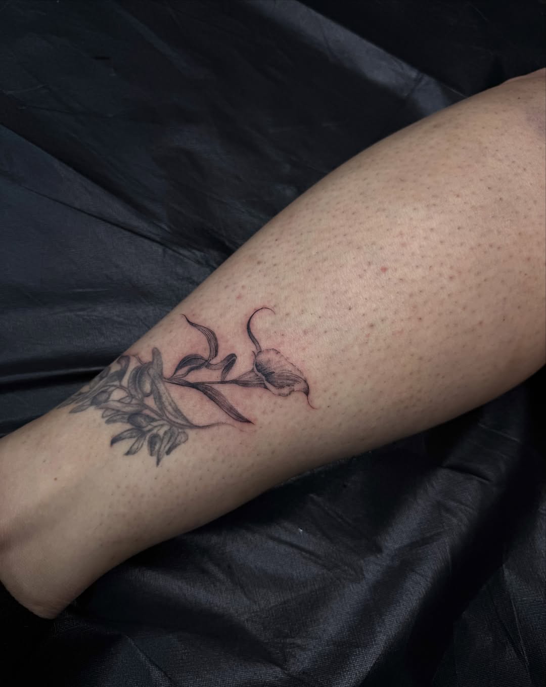 Flower and leaves black and grey tattoo on the forearm by Ava De La Torre
