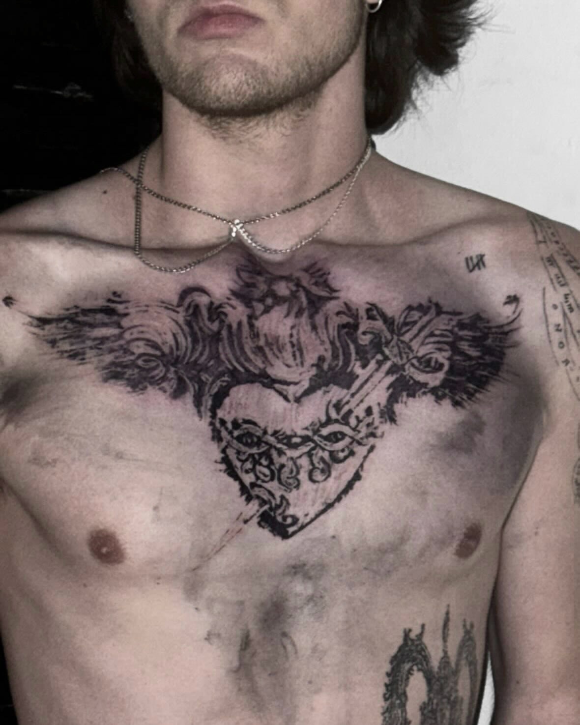Heart with wings black and grey tattoo on the chest by @douohv