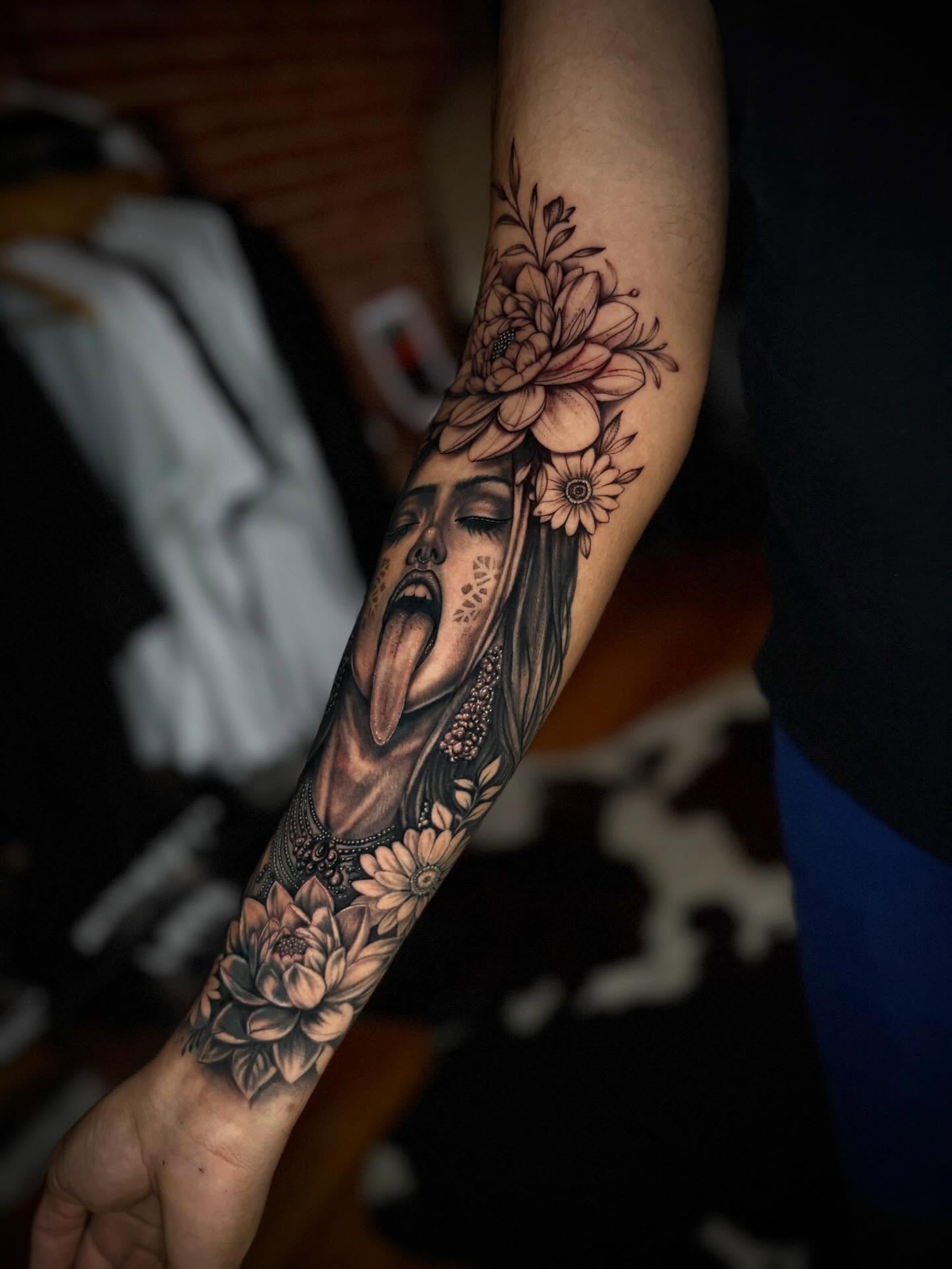 Woman with flowers realism tattoo on the forearm by JoannaTattoos