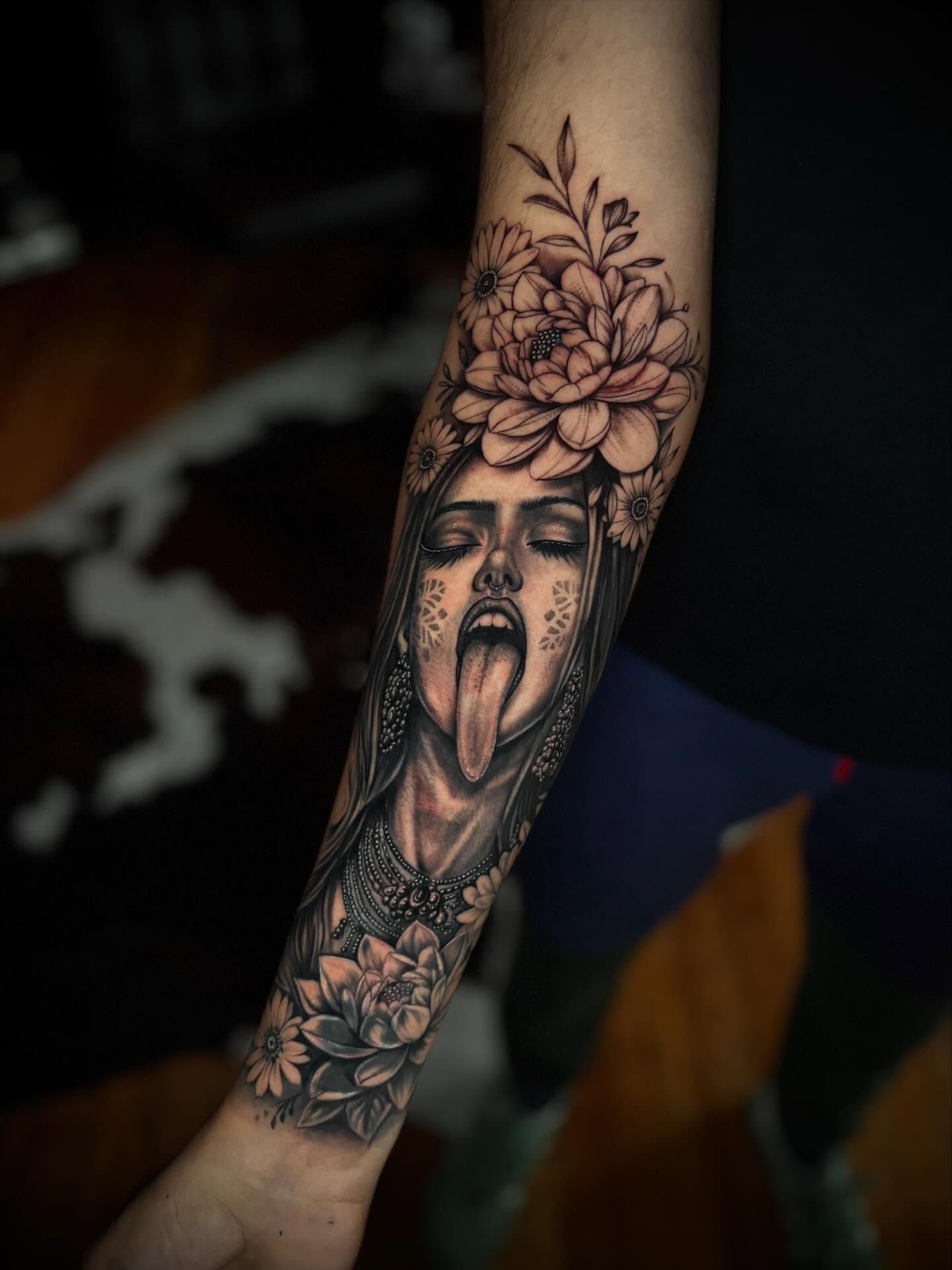 Woman with flowers realism tattoo on the forearm by JoannaTattoos