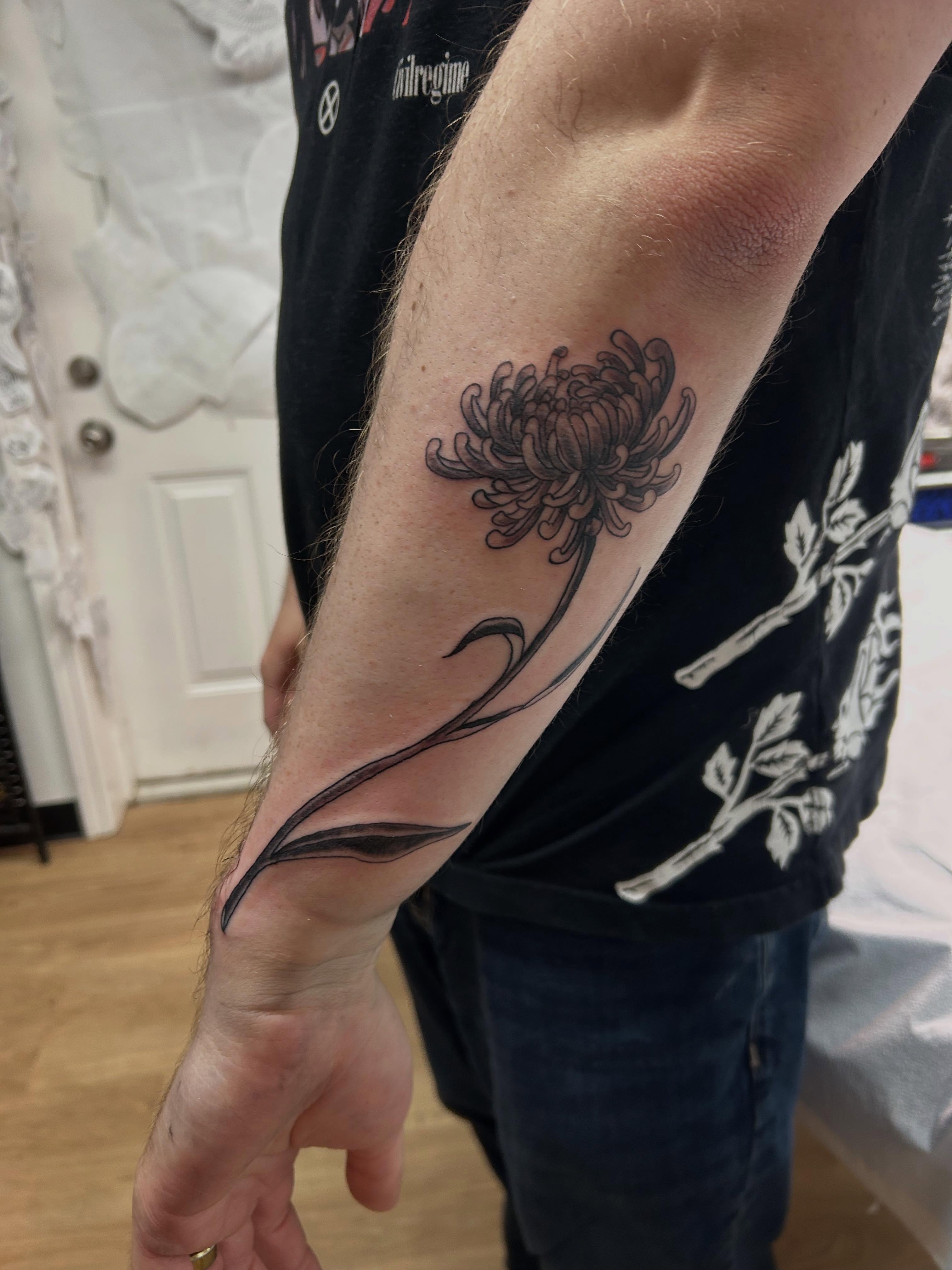 Chrysanthemum black and grey tattoo on the forearm by Stogie Tony