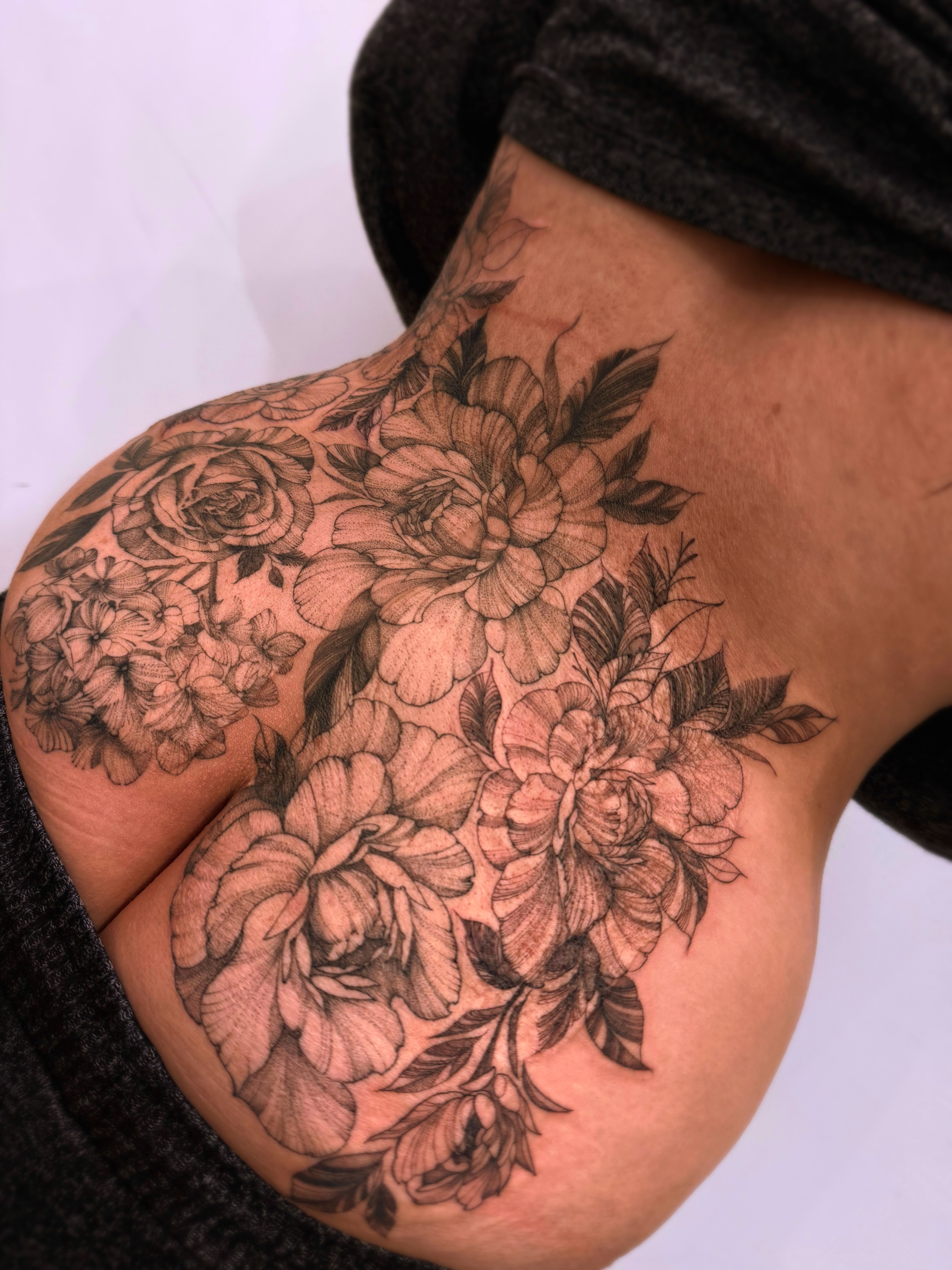 Floral bouquet black and grey tattoo on the shoulder by Tattoo Yulia Kononenko