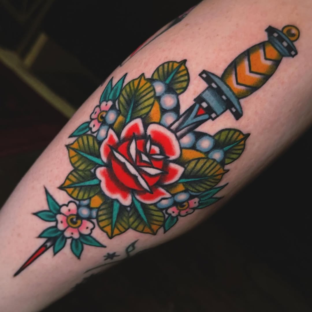 Dagger and rose American traditional tattoo on the forearm by Nikki Bee
