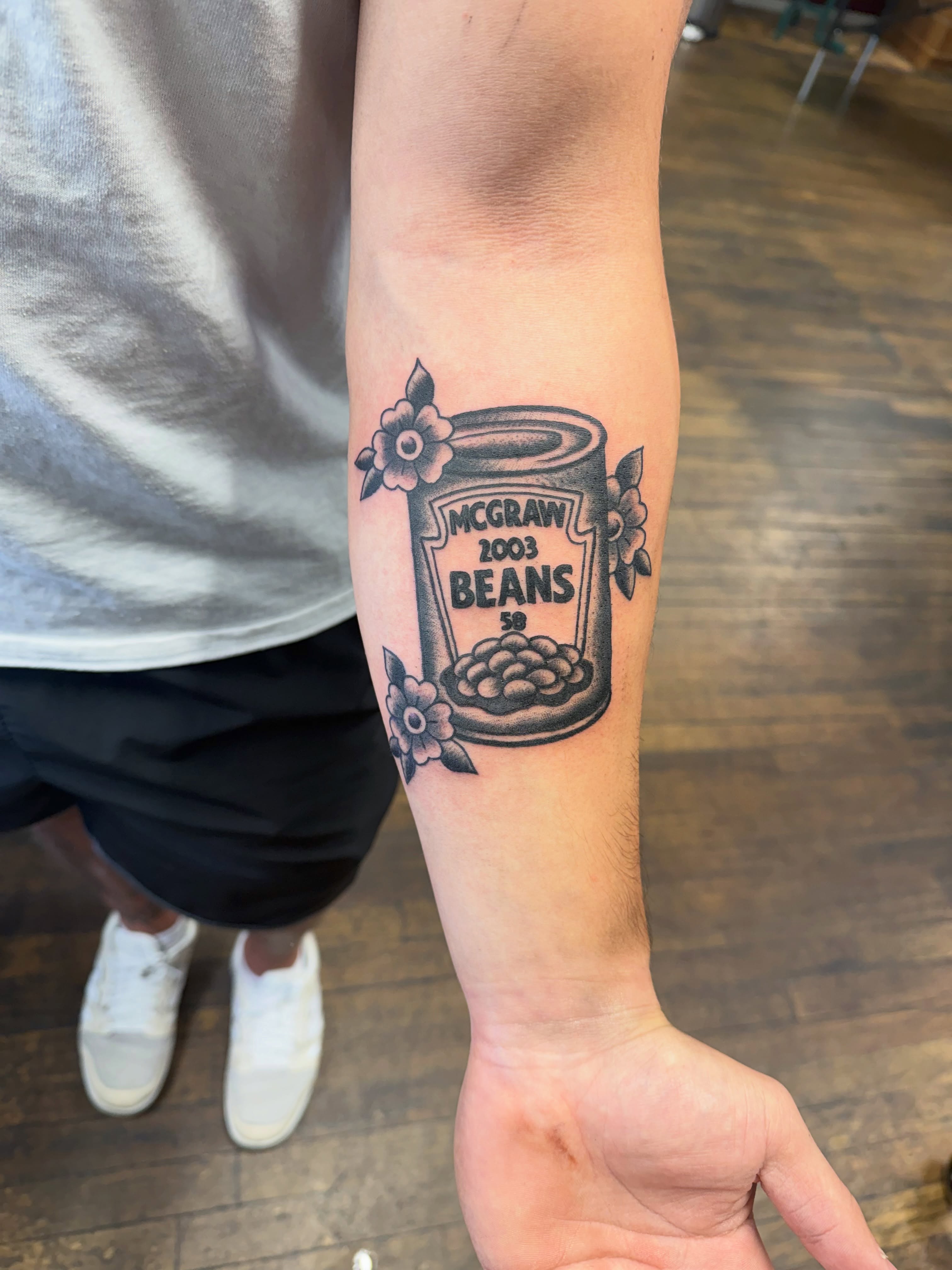 Bean can black and grey tattoo on the forearm by Aaron ulfstam