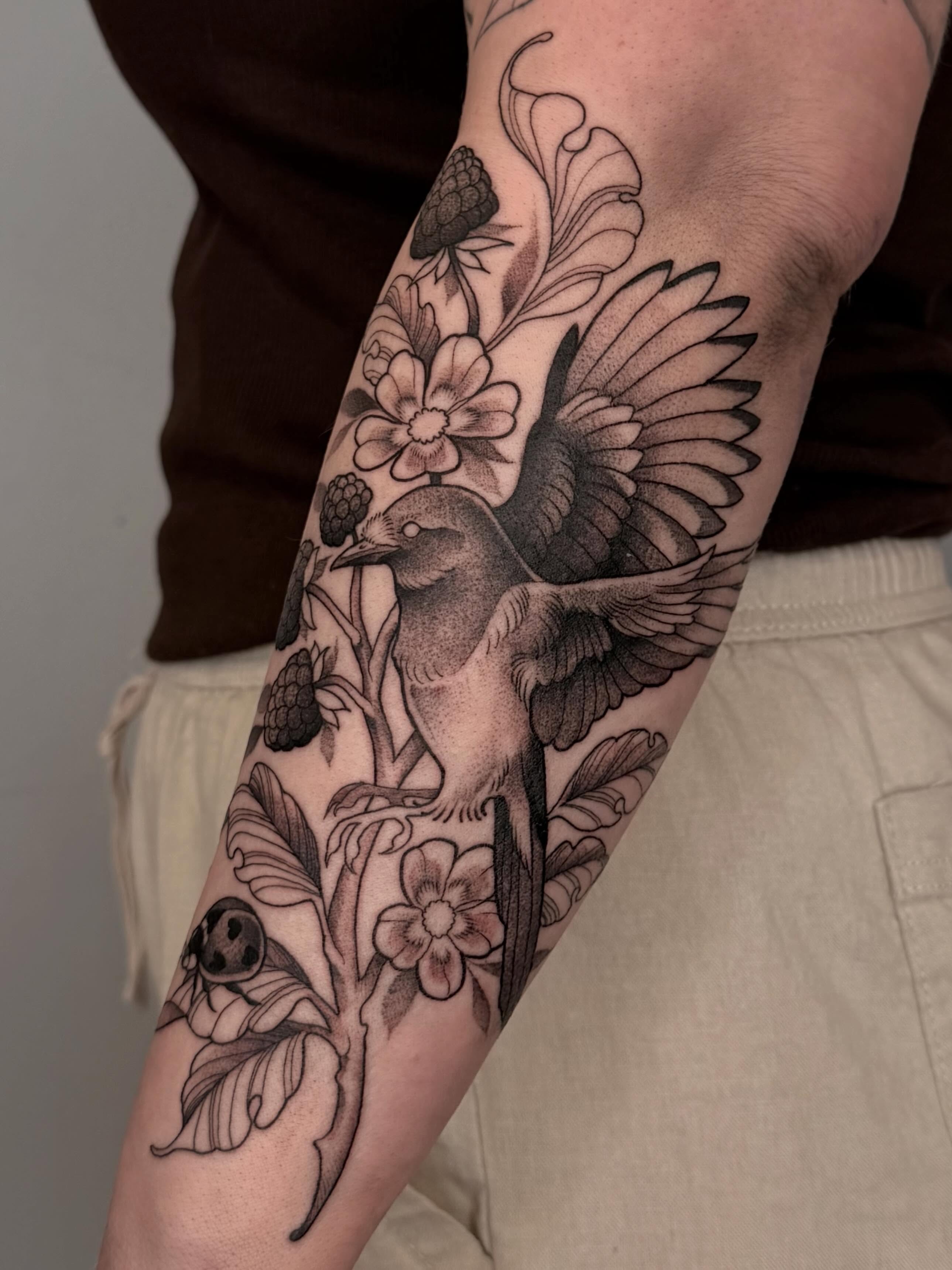 Bird and floral black and grey tattoo on the forearm by Destiny Illustration