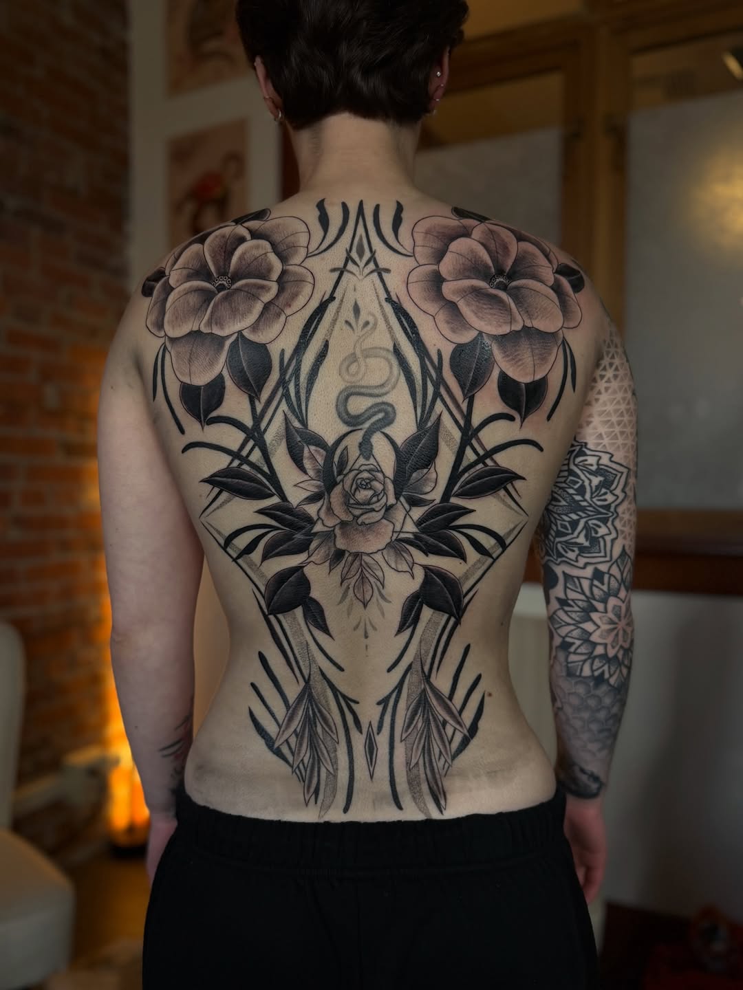 Floral arrangement with snake tribal tattoo on the back by แดแด ๐ฎ๐ท ๐ฆ๐ซ