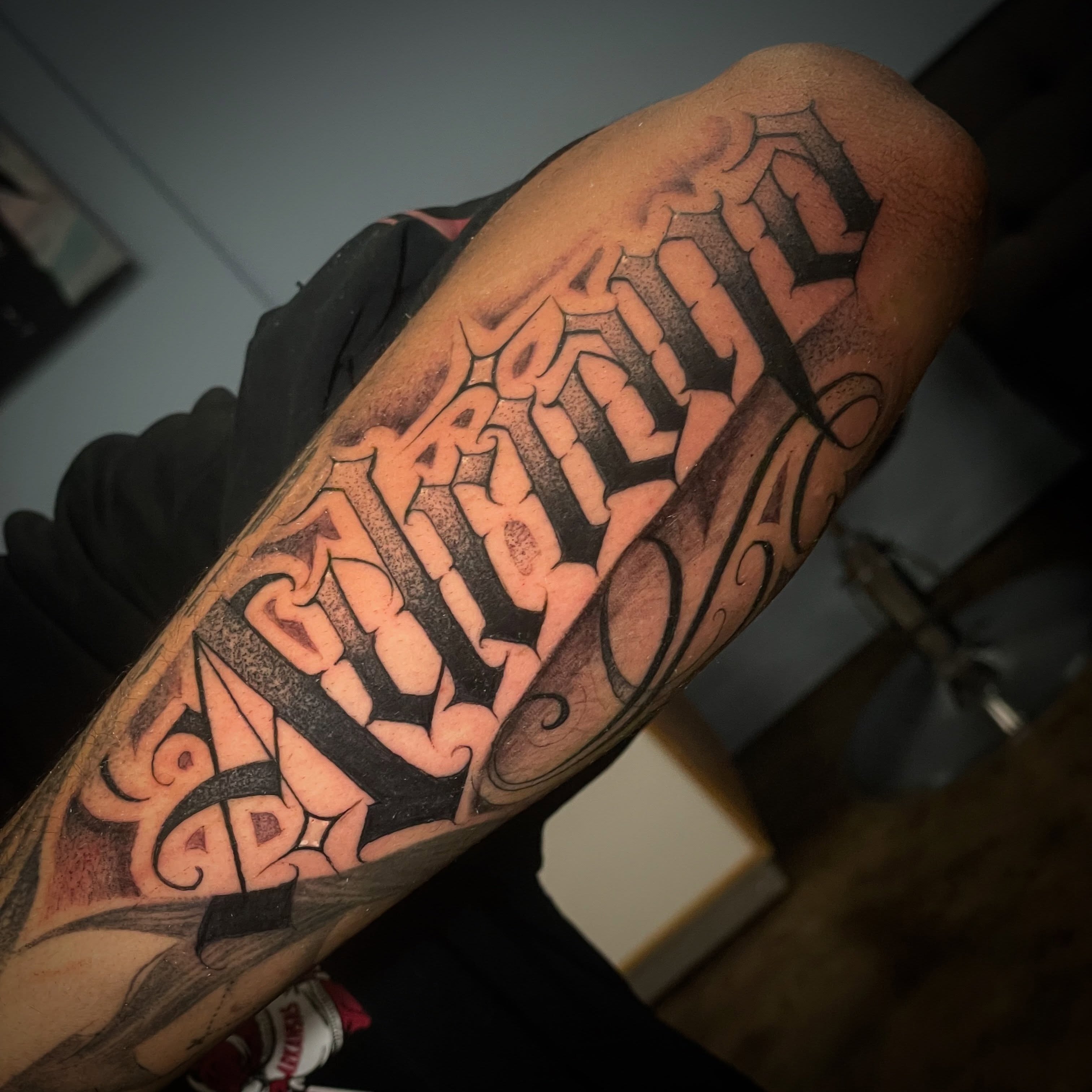 Family lettering script tattoo on the forearm by Shadoww Espinoza