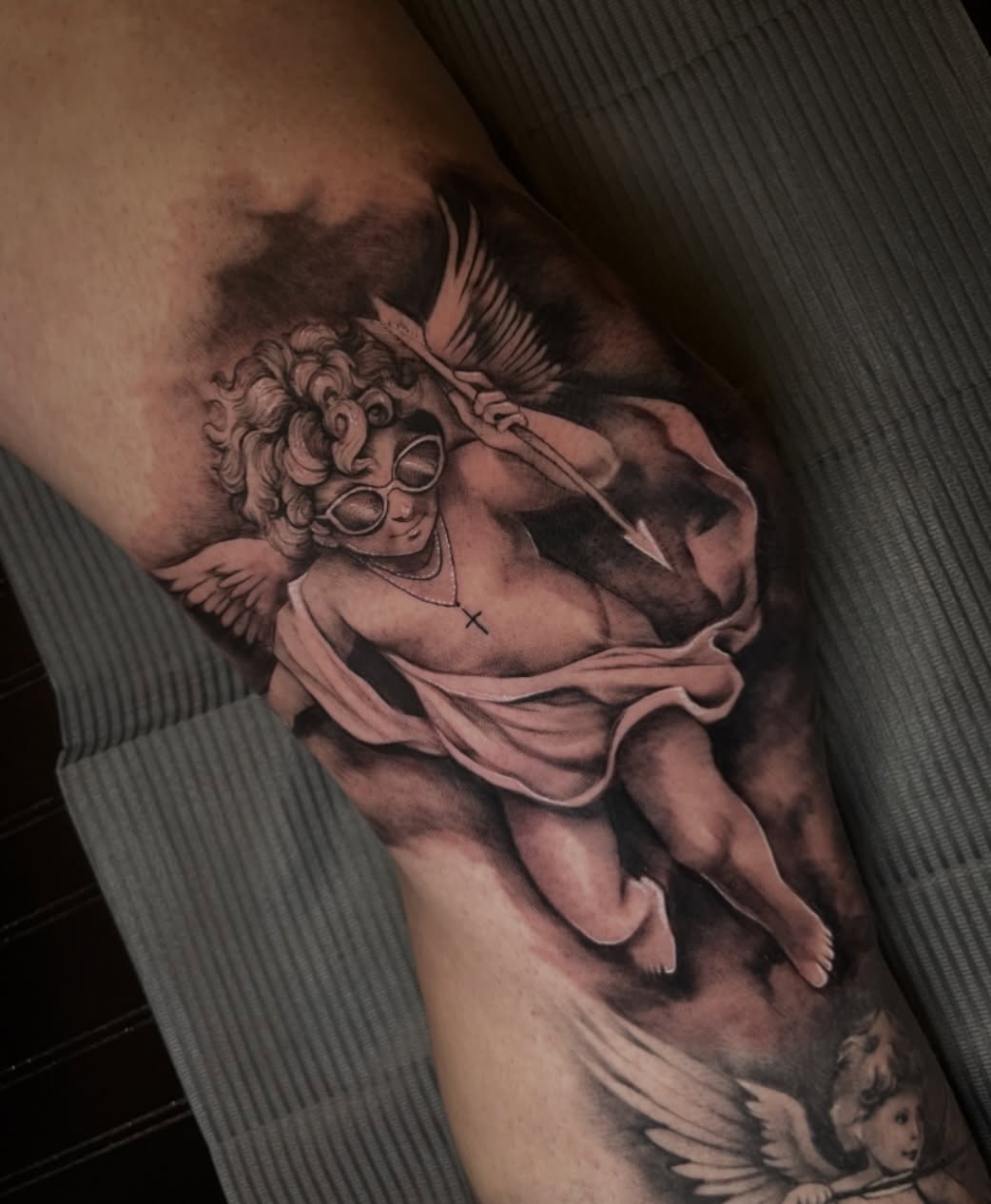 Angel with sunglasses realism tattoo on the thigh by Erica Olivier