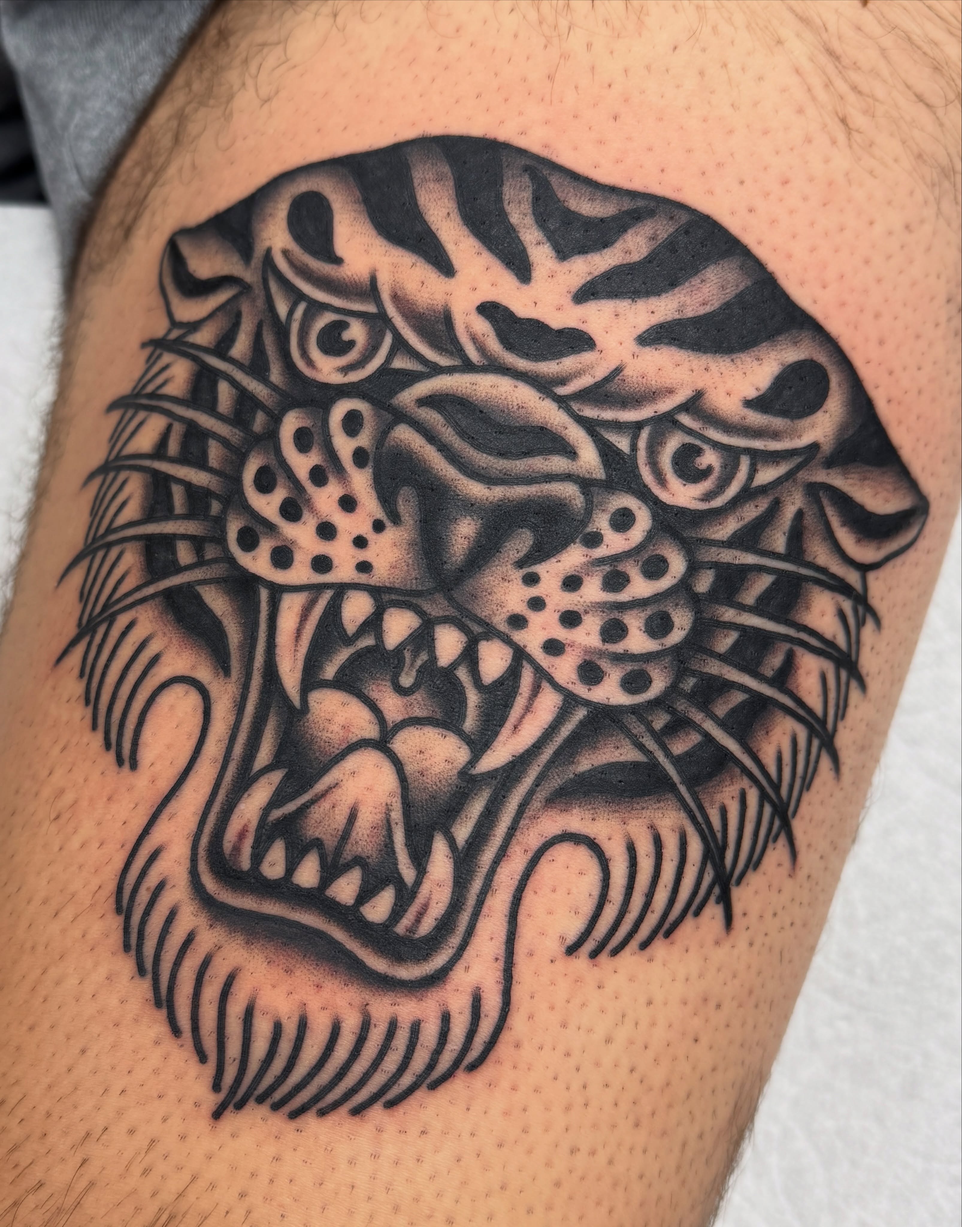 Roaring panther black and grey tattoo on the thigh by Joey Burdette Tattoos