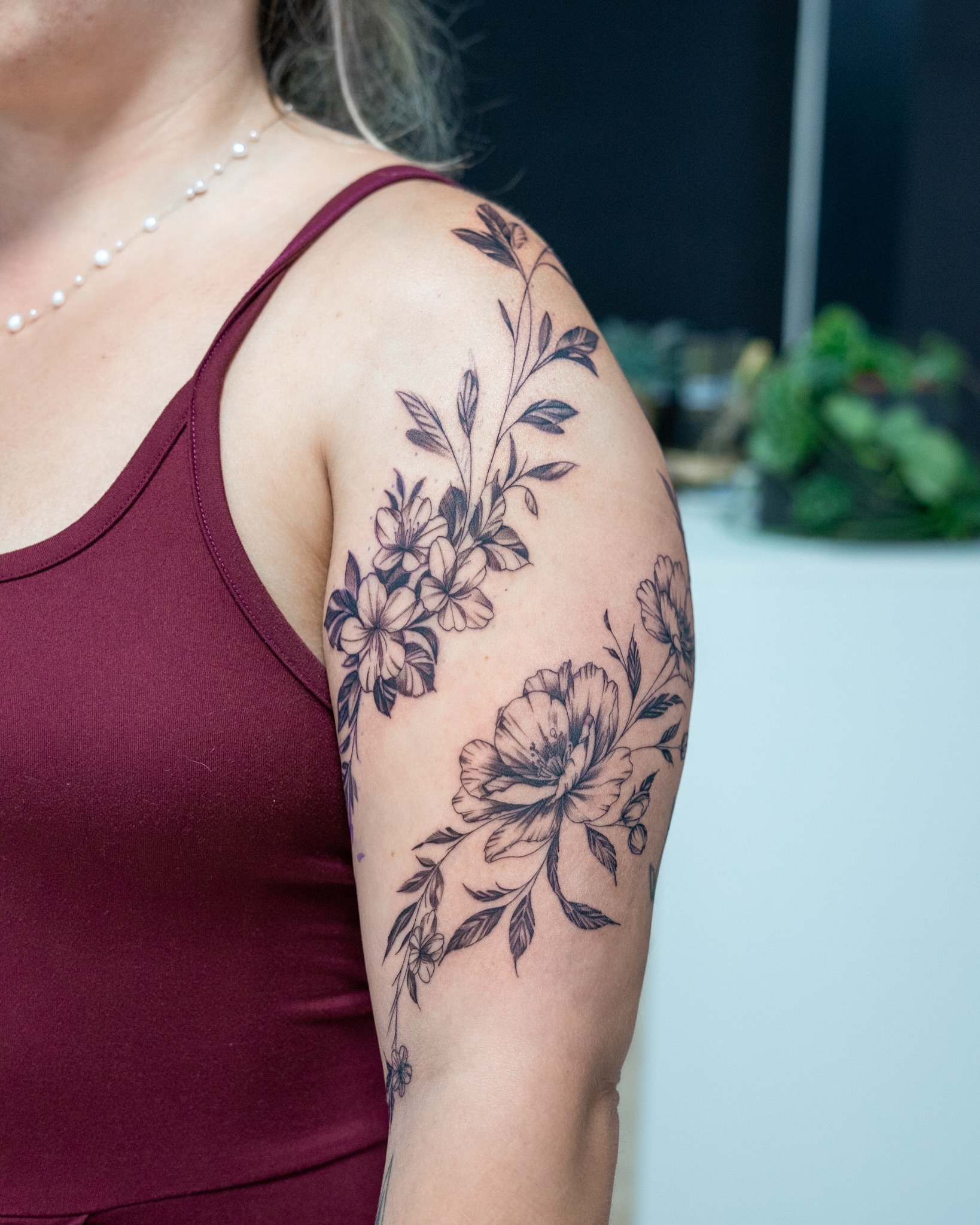 Floral bouquet black and grey tattoo on the shoulder by The Tattoo Plug
