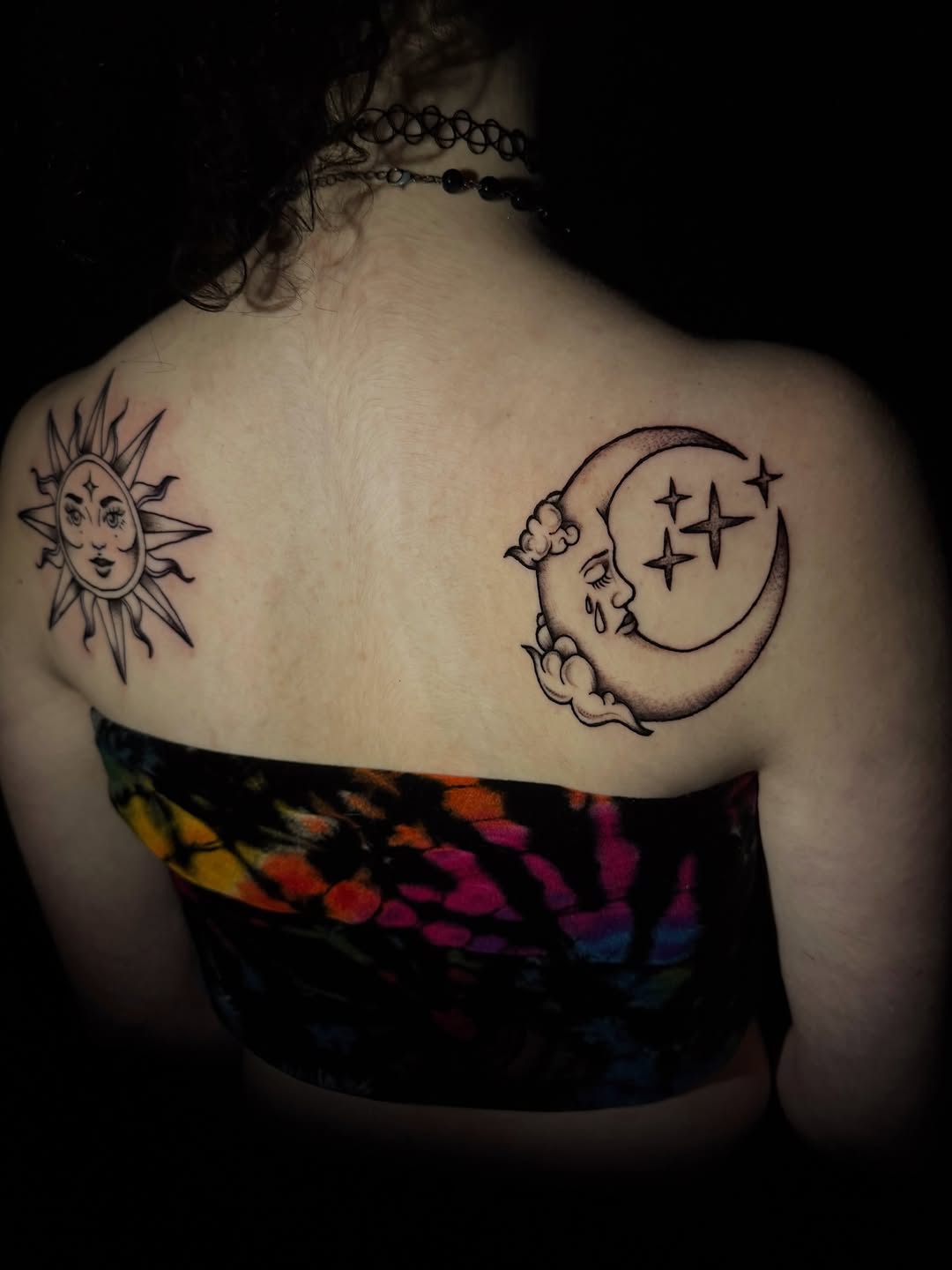 Sun and crying moon with stars tattoo on the back by licensed charlotte tattoo artist