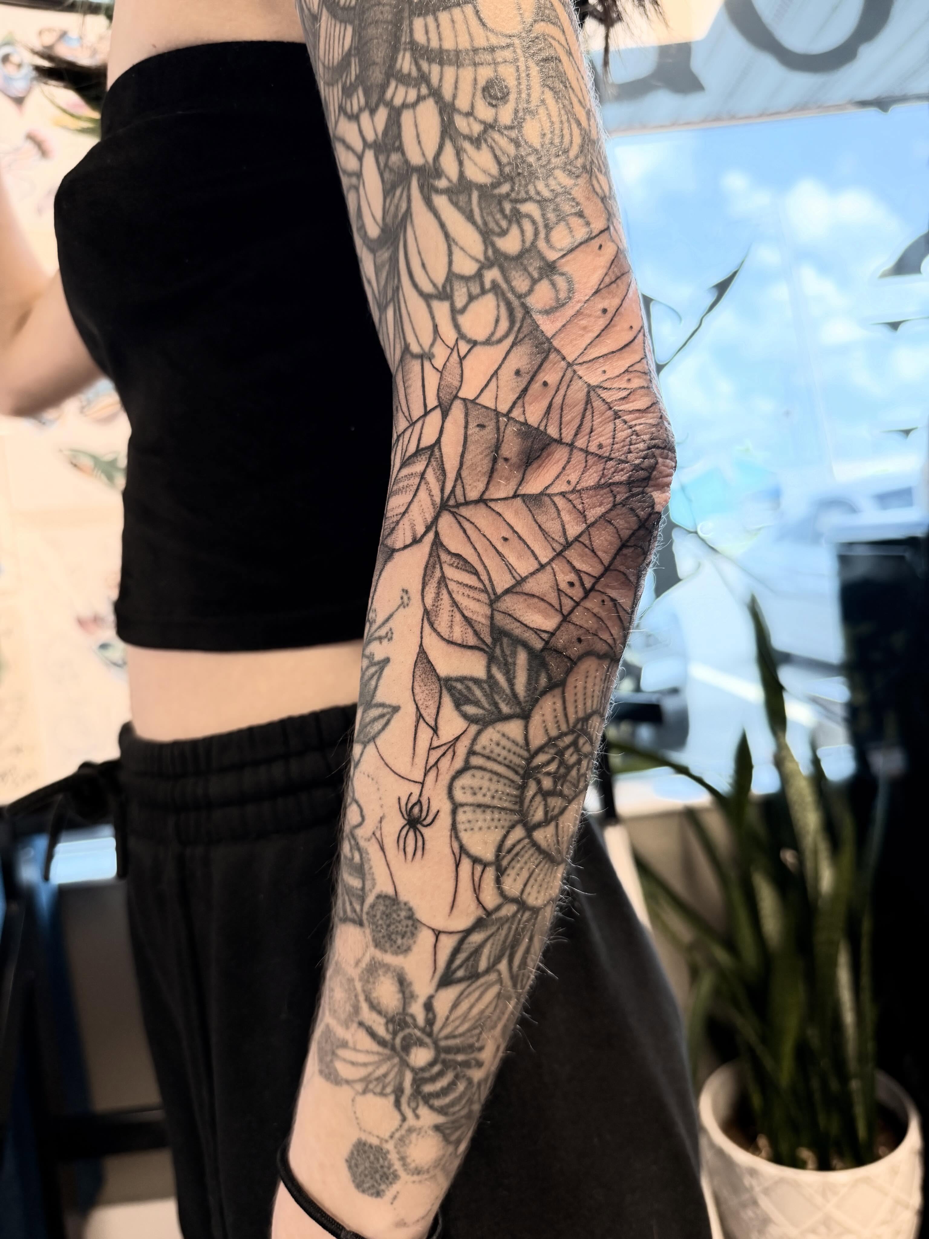 Floral and bee dotwork tattoo on the forearm by Shannon Misitano