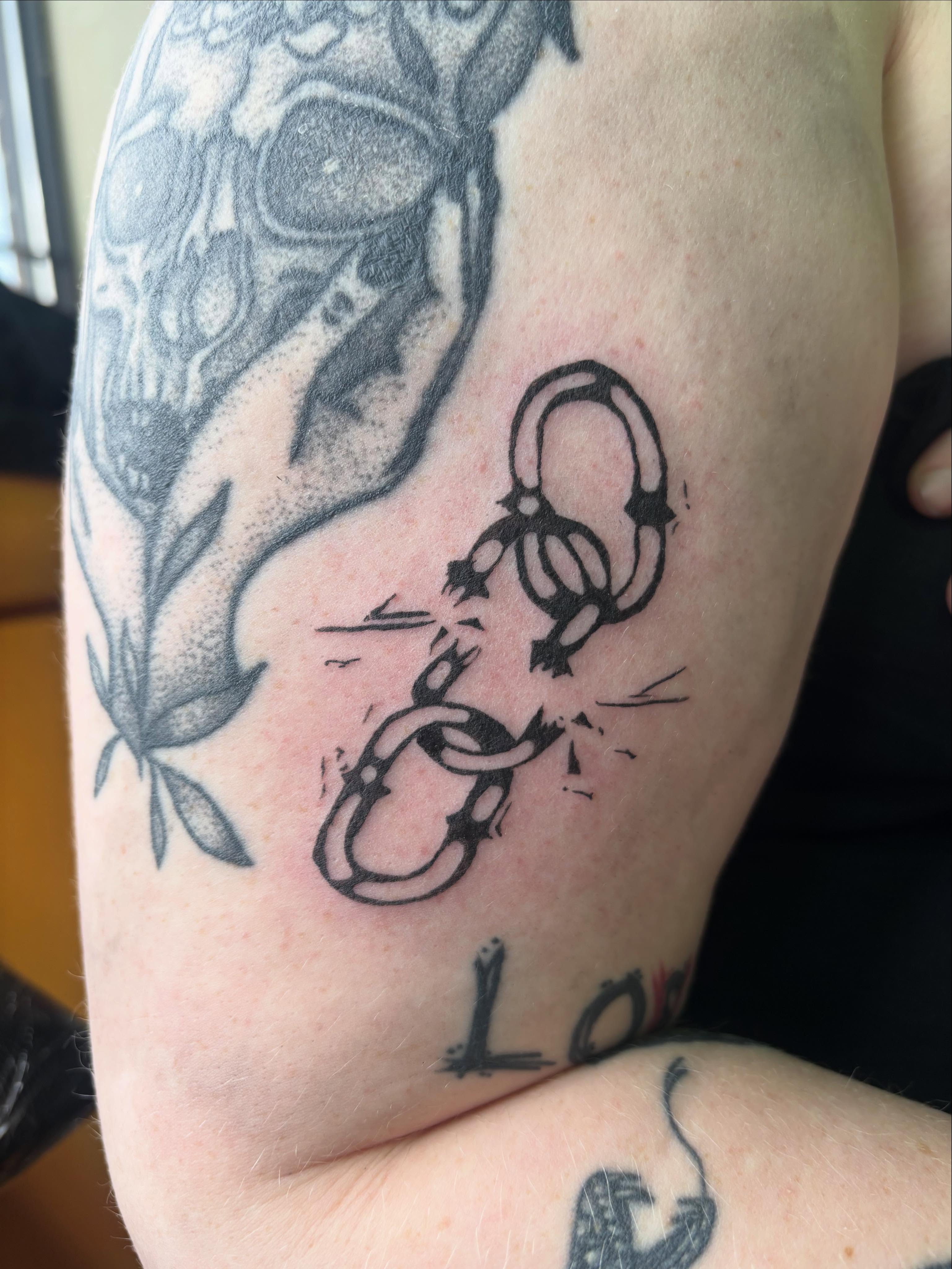Broken chains black and grey tattoo on the forearm by Hiro Robinson