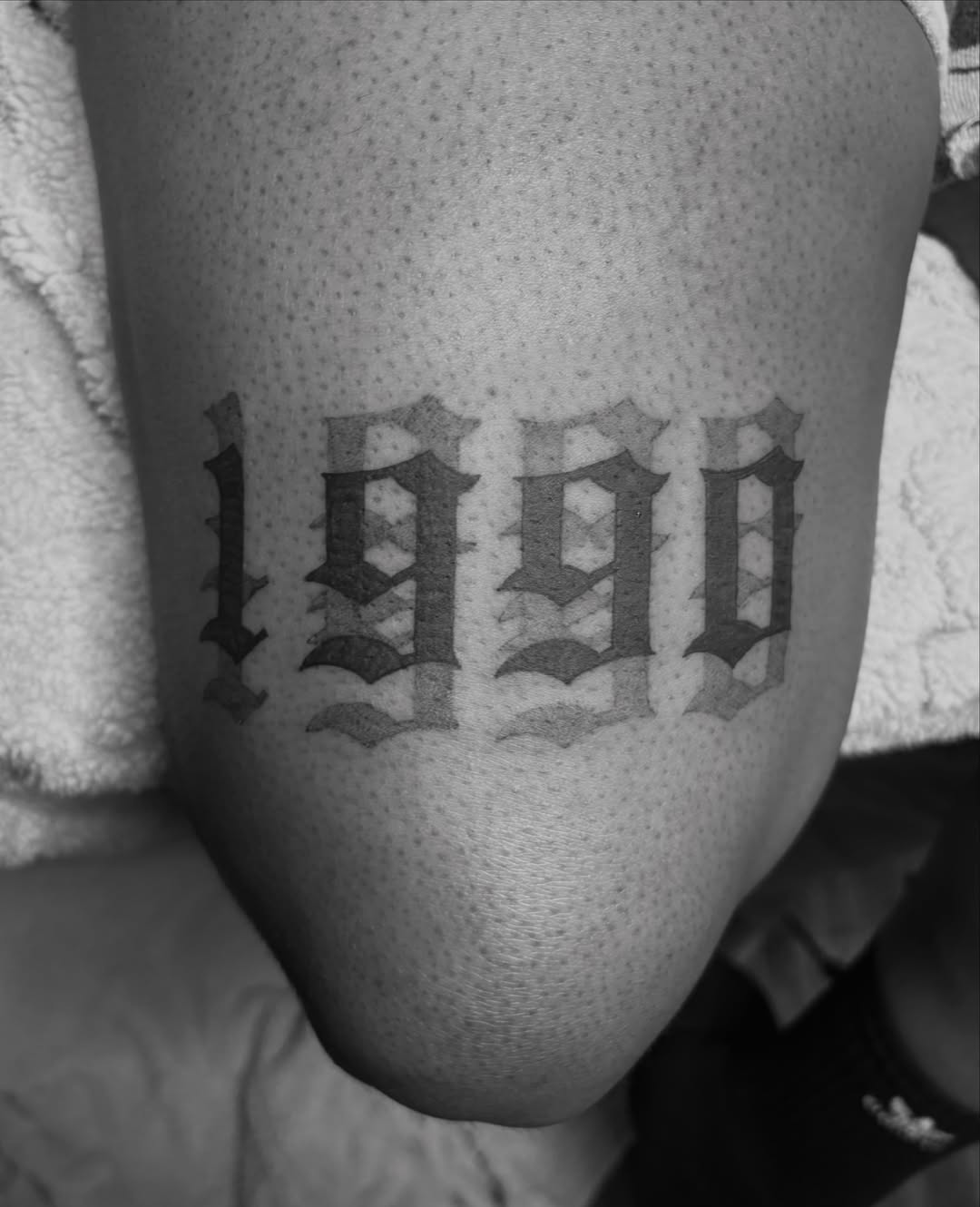1990 black and grey tattoo on the thigh by @secretlinetattoo