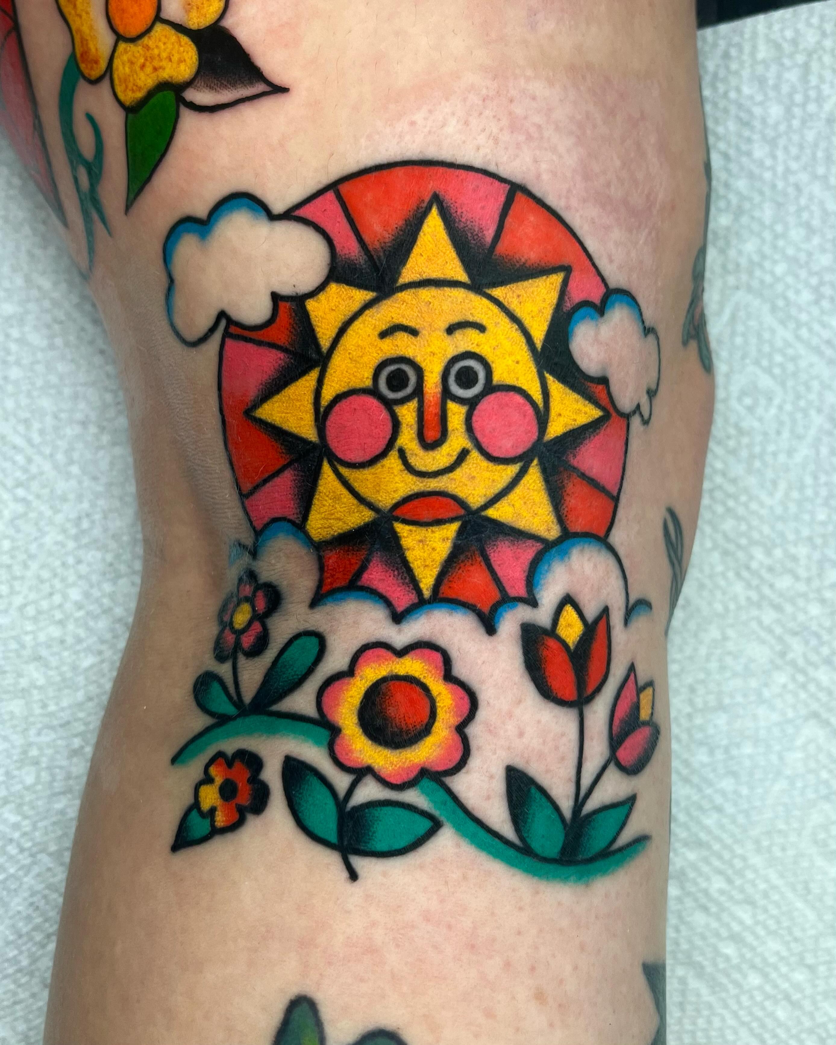 Sun and flowers American traditional tattoo on the forearm by Em Adkins