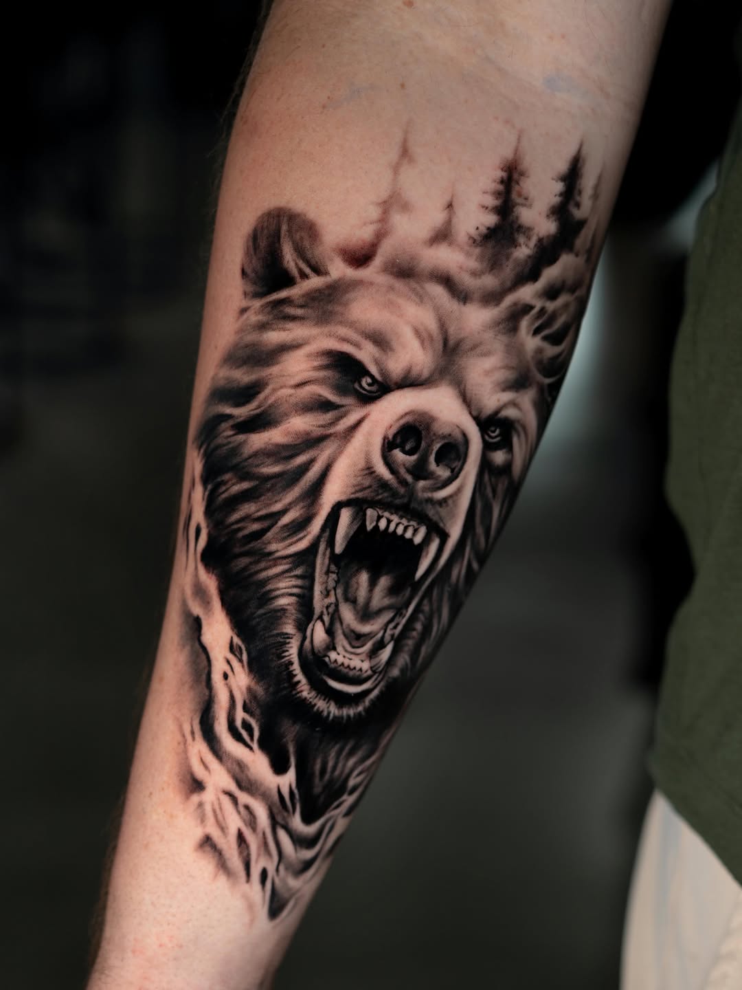 Roaring bear head with trees realism tattoo on the forearm by Charlotte Tattoo Artist