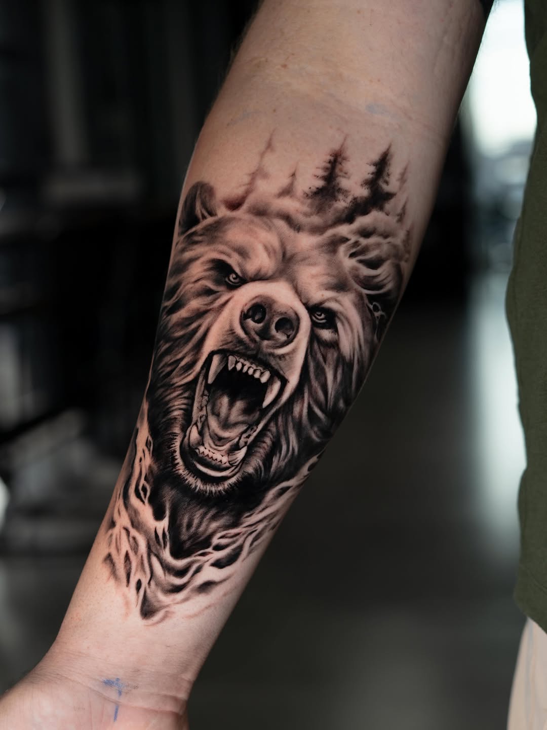 Roaring bear with trees realism tattoo on the forearm by Charlotte Tattoo Artist