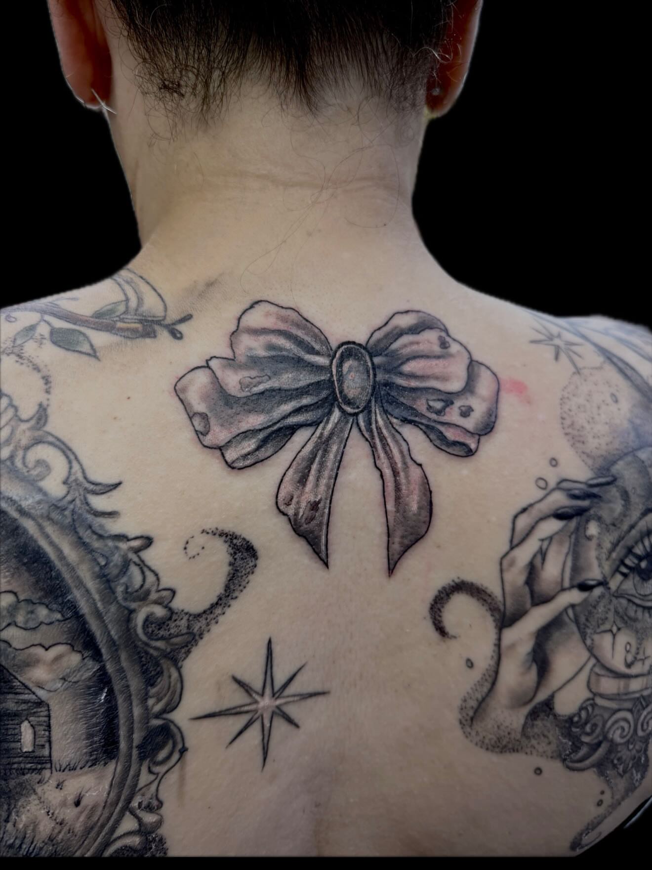 Bow black and grey tattoo on the back by ⋆༺⋆˖⁺‧₊  ☽  ⛦⃝  ☾  ₊‧⁺˖⋆༻⋆𝔄𝔩𝔬𝔫𝔡𝔯𝔞  🌾