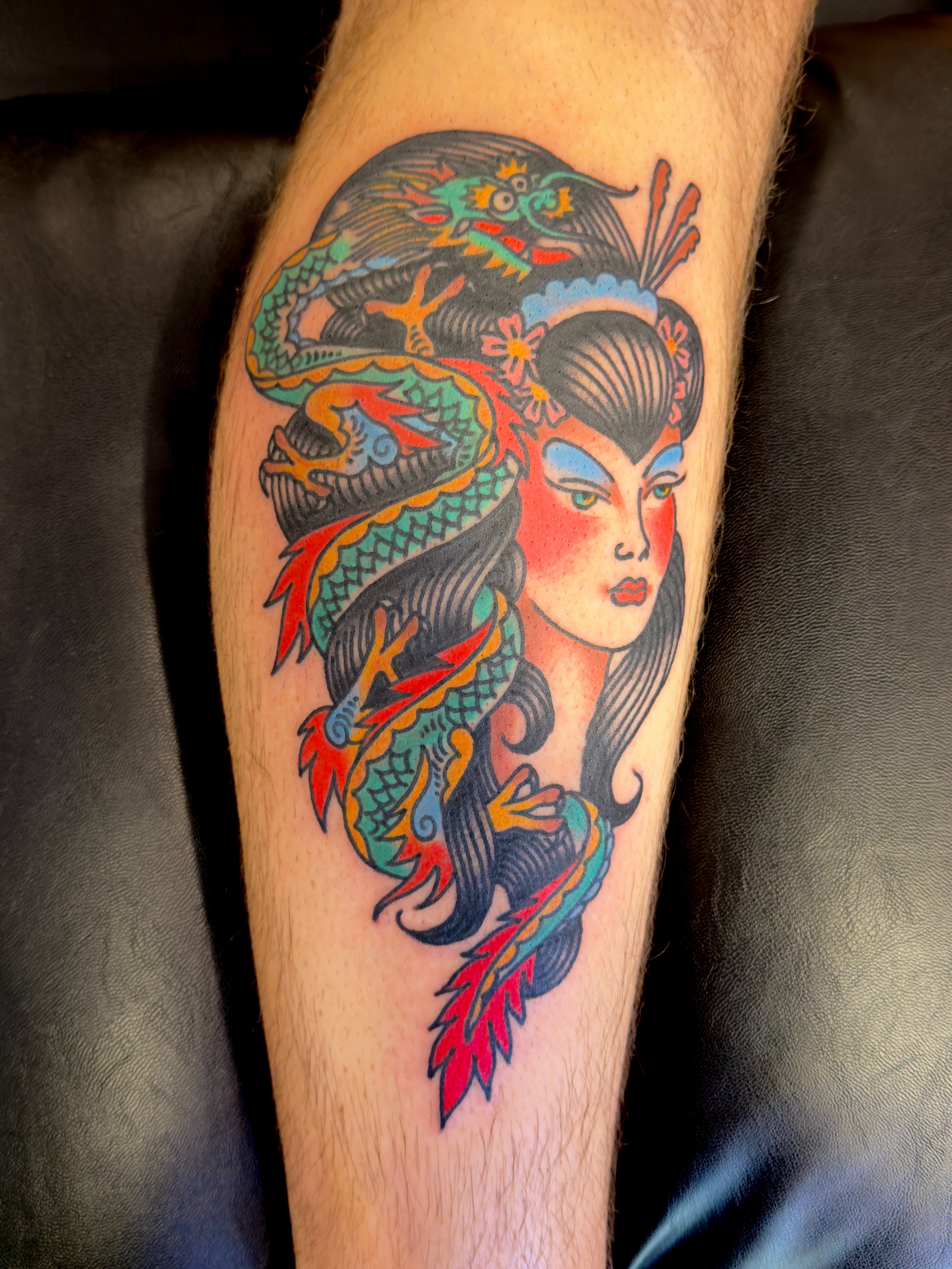 Geisha with dragon American traditional tattoo on the forearm by Jimmy Kelley