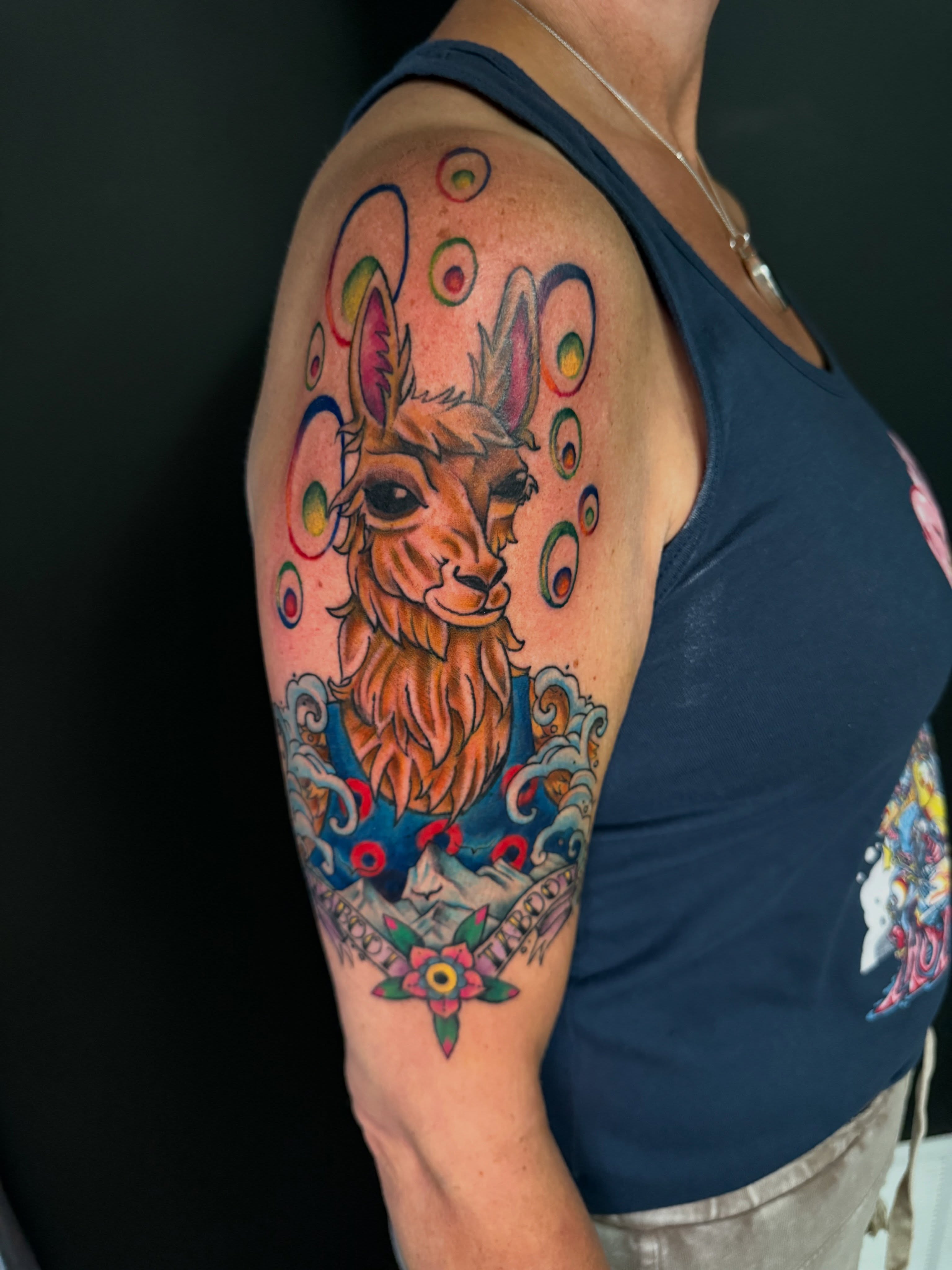 Llama new school tattoo on the upper arm by Michelle Balhan