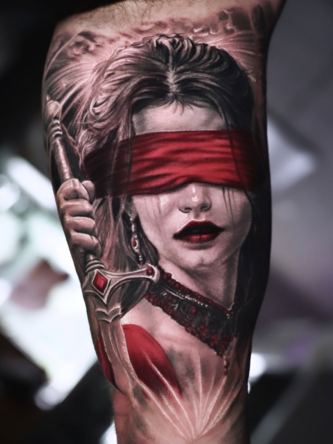 Blindfolded woman with sword realism tattoo on the forearm by Chris Bowling