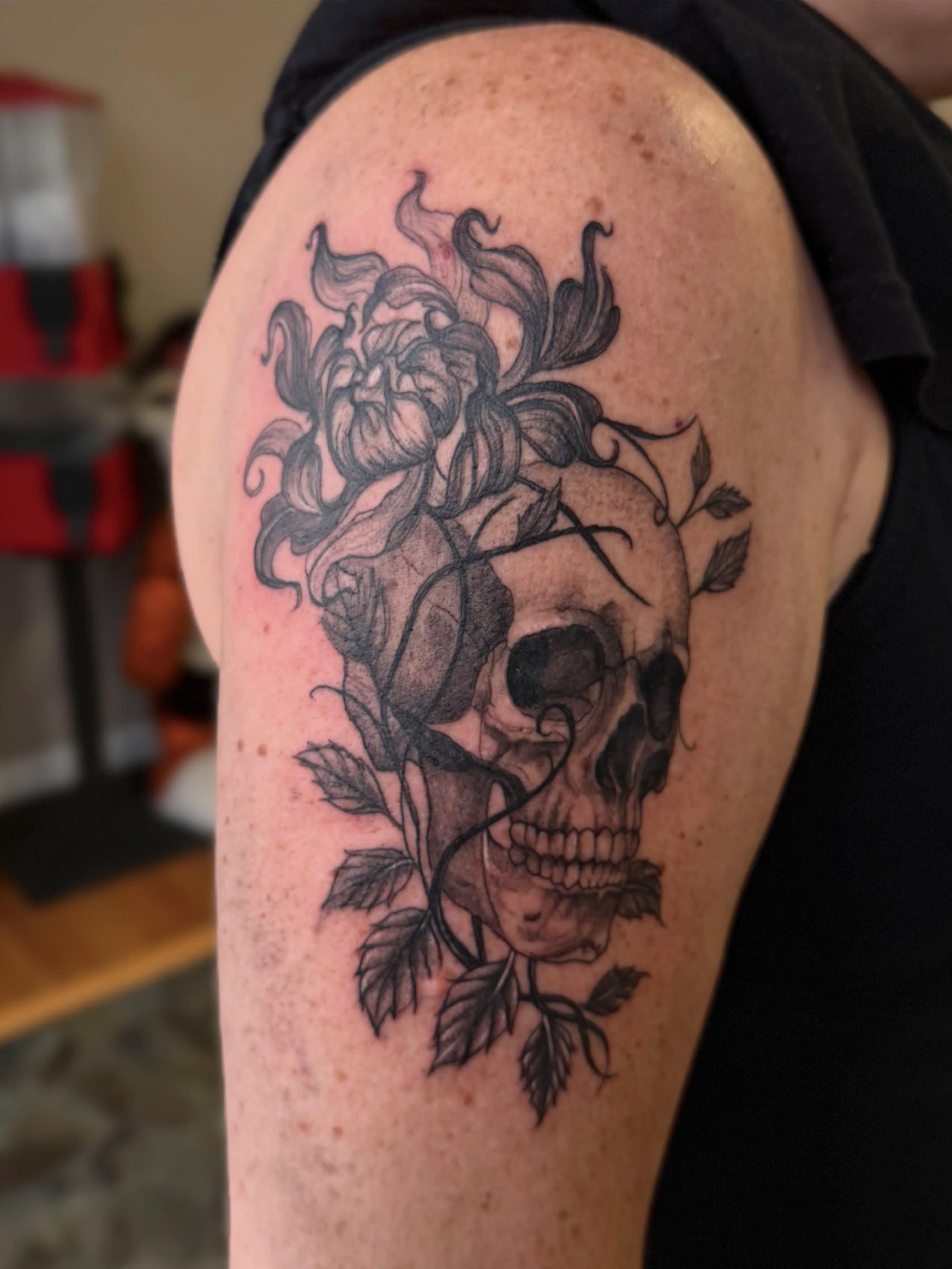 Skull and flower realism tattoo on the shoulder by Skylar Sheeley