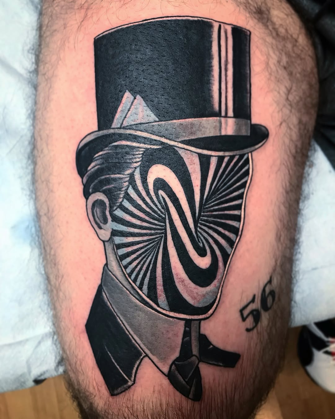 Top hat and spiral geometric tattoo on the thigh by Brian DiCola Tattooer