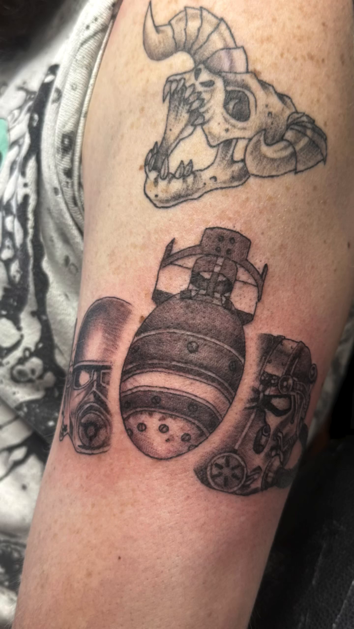 Post-apocalyptic figures and bombs tattoo on the forearm by Teagan Rachel, Millcreek, Utah