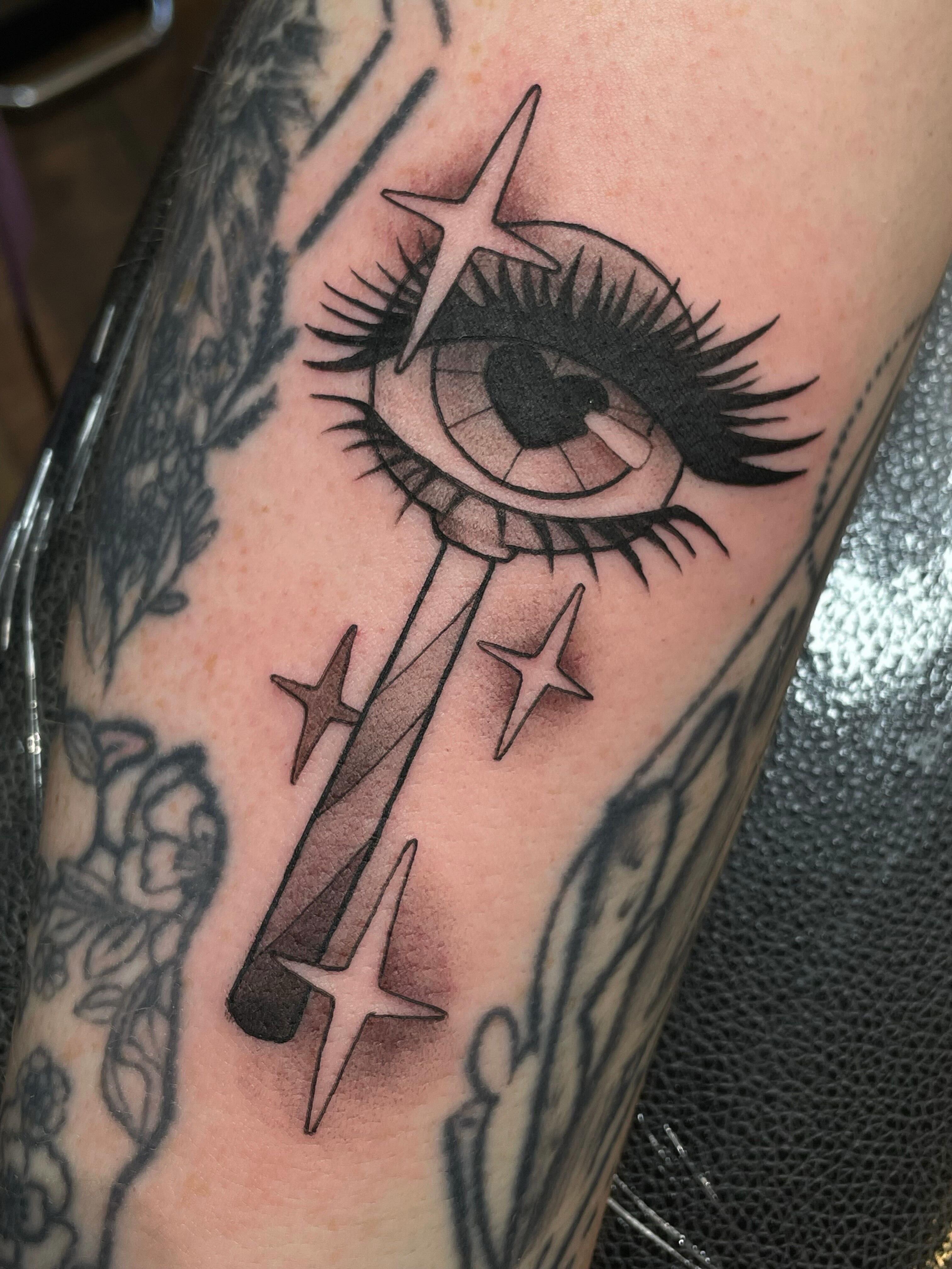 Eye with stars black and grey tattoo on the forearm by Tanya Murski