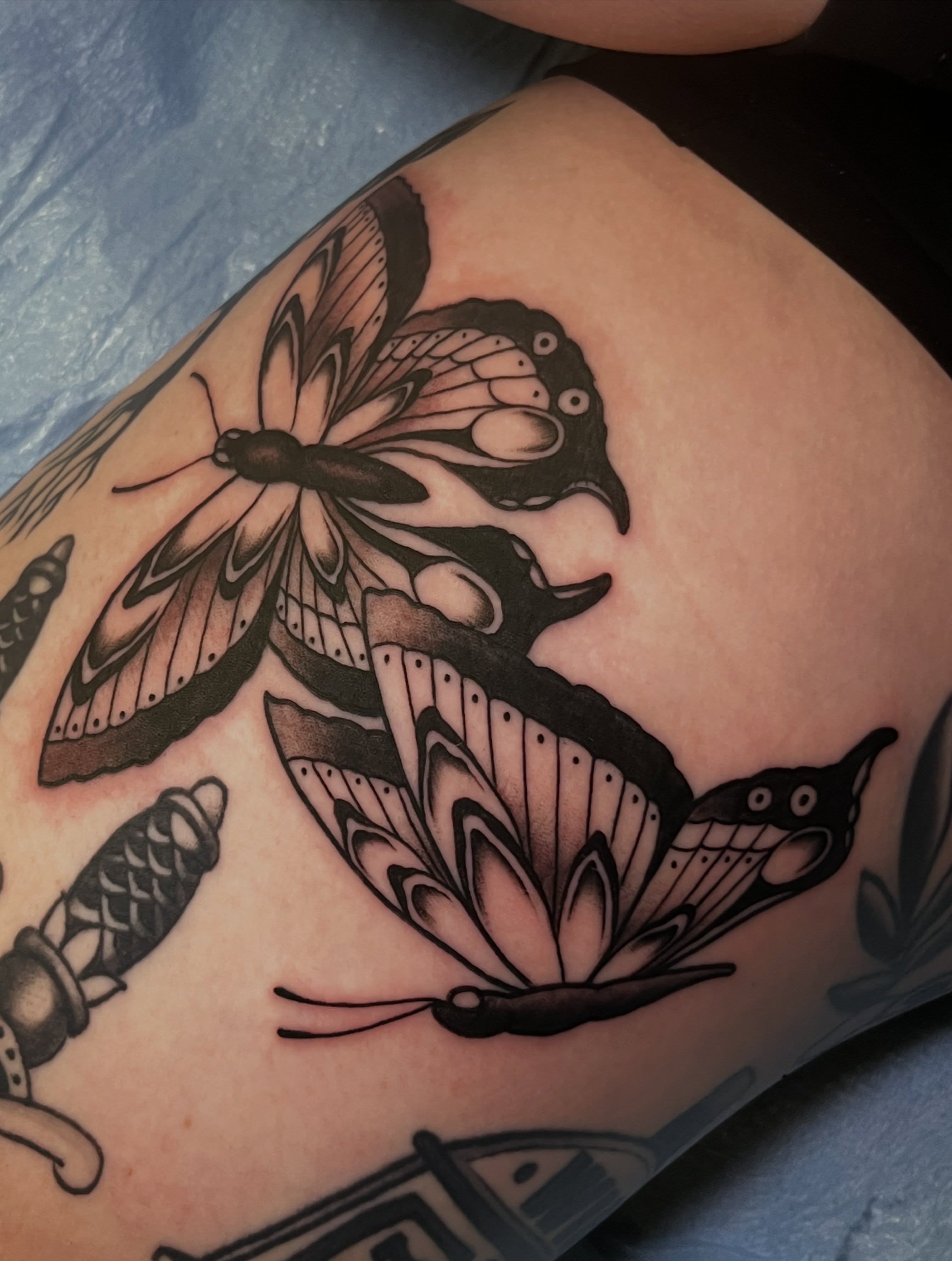 Butterfly black and grey tattoo on the thigh by Evan Perrine